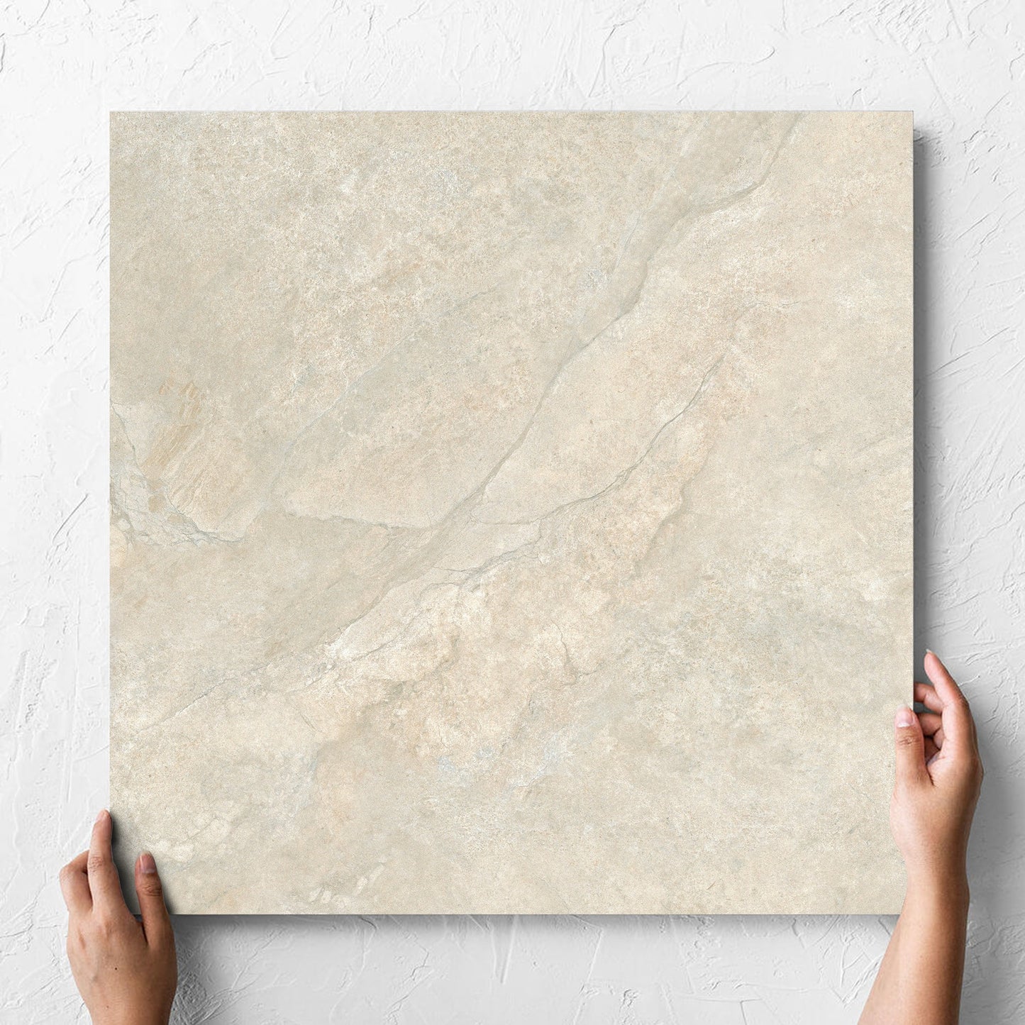 Hand holding a single Lakestone Natural Matt 600x600mm tile against a white rendered wall, showing the matt surface