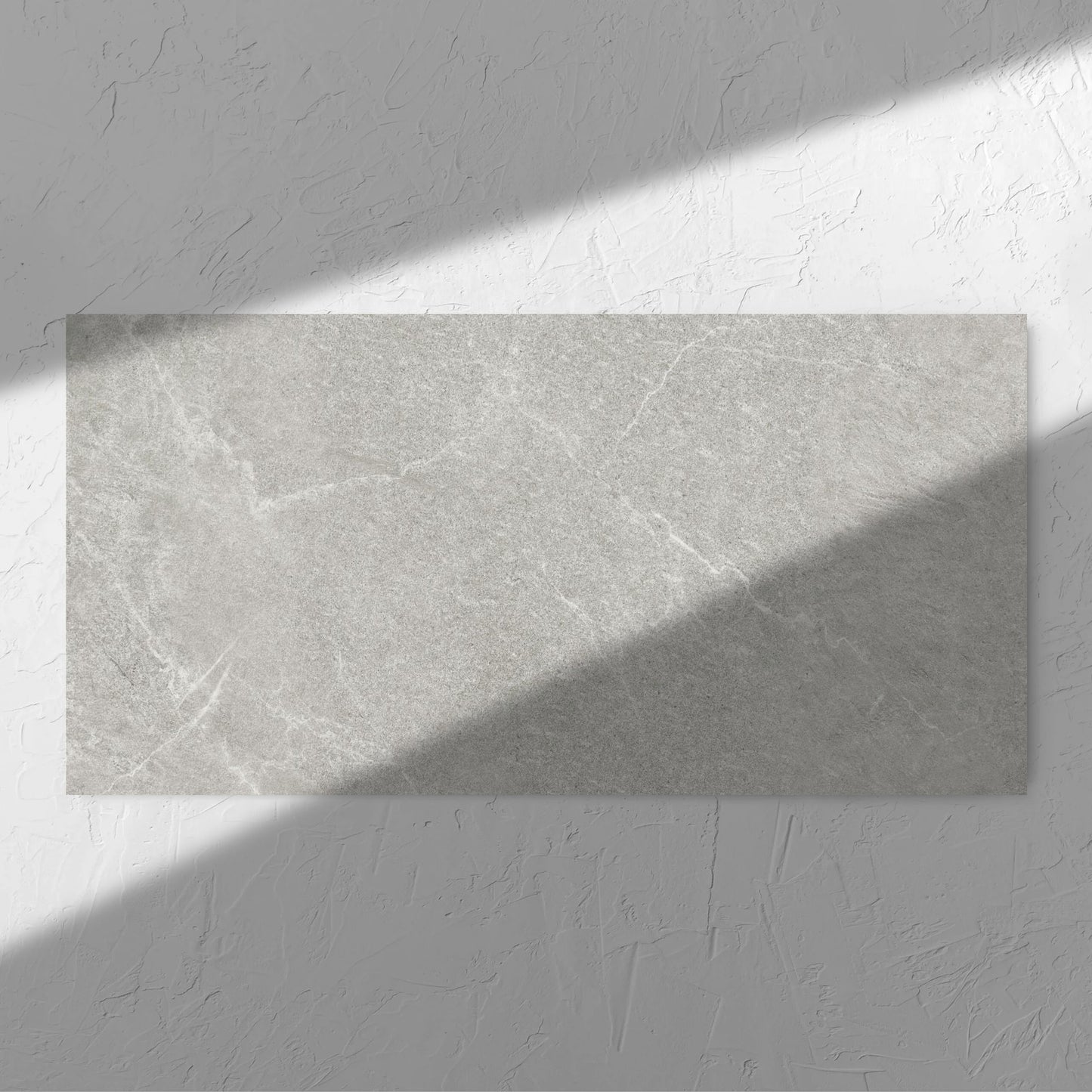 Lava Ash Amber 600x1200mm tile in soft natural window light, showing the ash surface