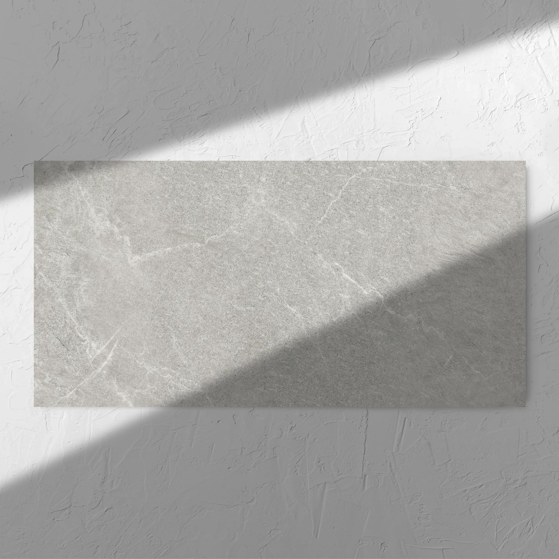 Lava Ash Amber 600x1200mm tile in soft natural window light, showing the ash surface