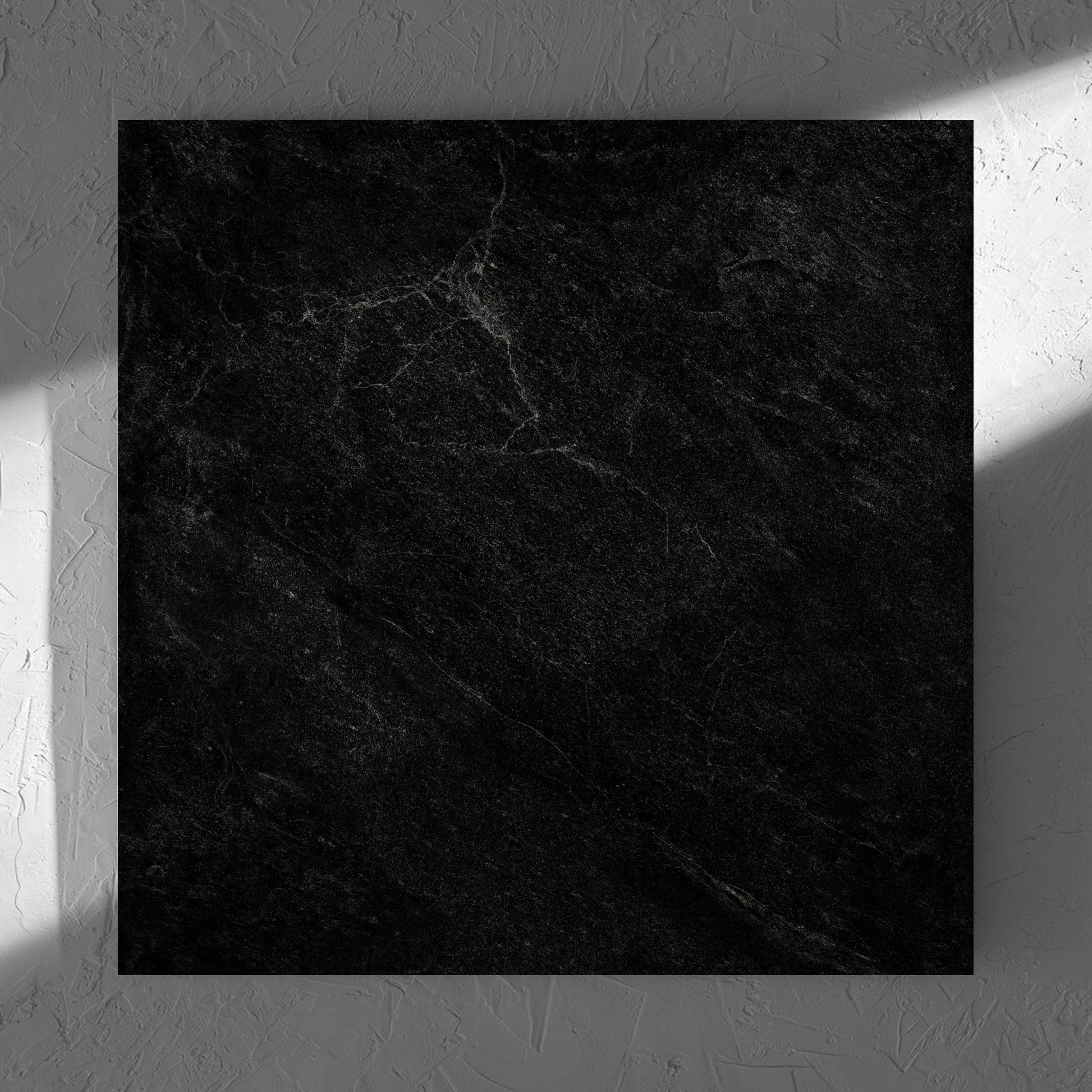 Lava Black Rect Inout 600x600mm tile in soft natural window light, showing the tile surface