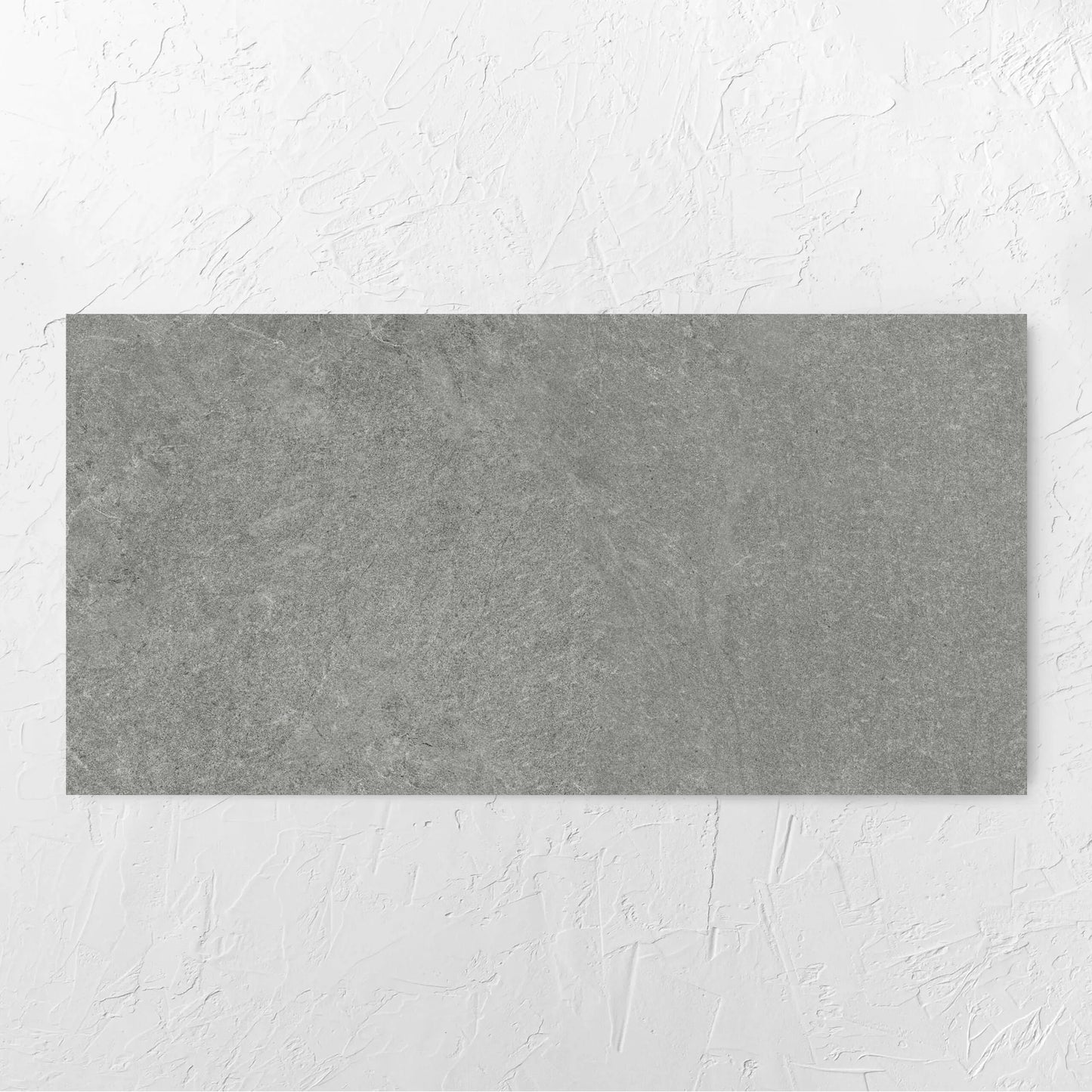 Lava Grey Amber 600x1200mm tile laid flat on a white rendered wall, showing the grey surface