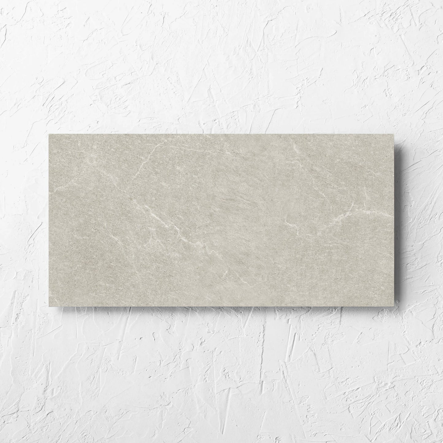 Lava Soft Beige Amber 300x600mm tile laid flat on a white rendered wall, showing the soft beige lappato surface