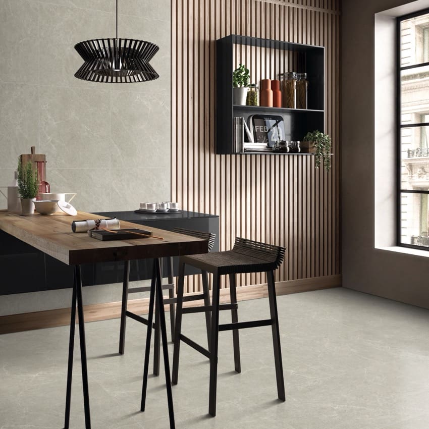 Lava Soft Beige Amber 300x600mm porcelain tiles installed on kitchen floor and wall behind a dark wood breakfast bar with black pendant light and slatted timber feature wall.