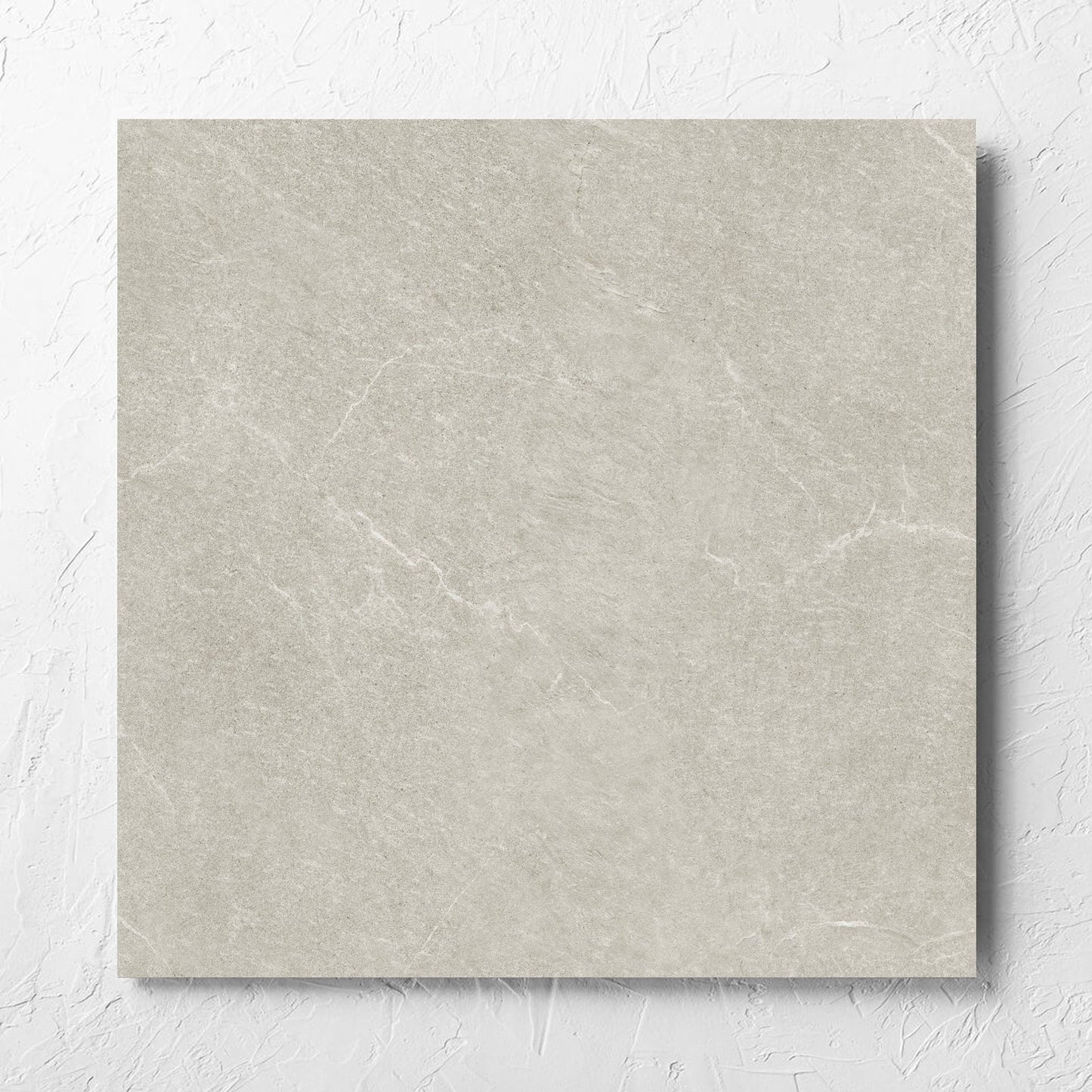 Lava Soft Beige Amber 600x600mm tile laid flat on a white rendered wall, showing the soft beige lappato surface