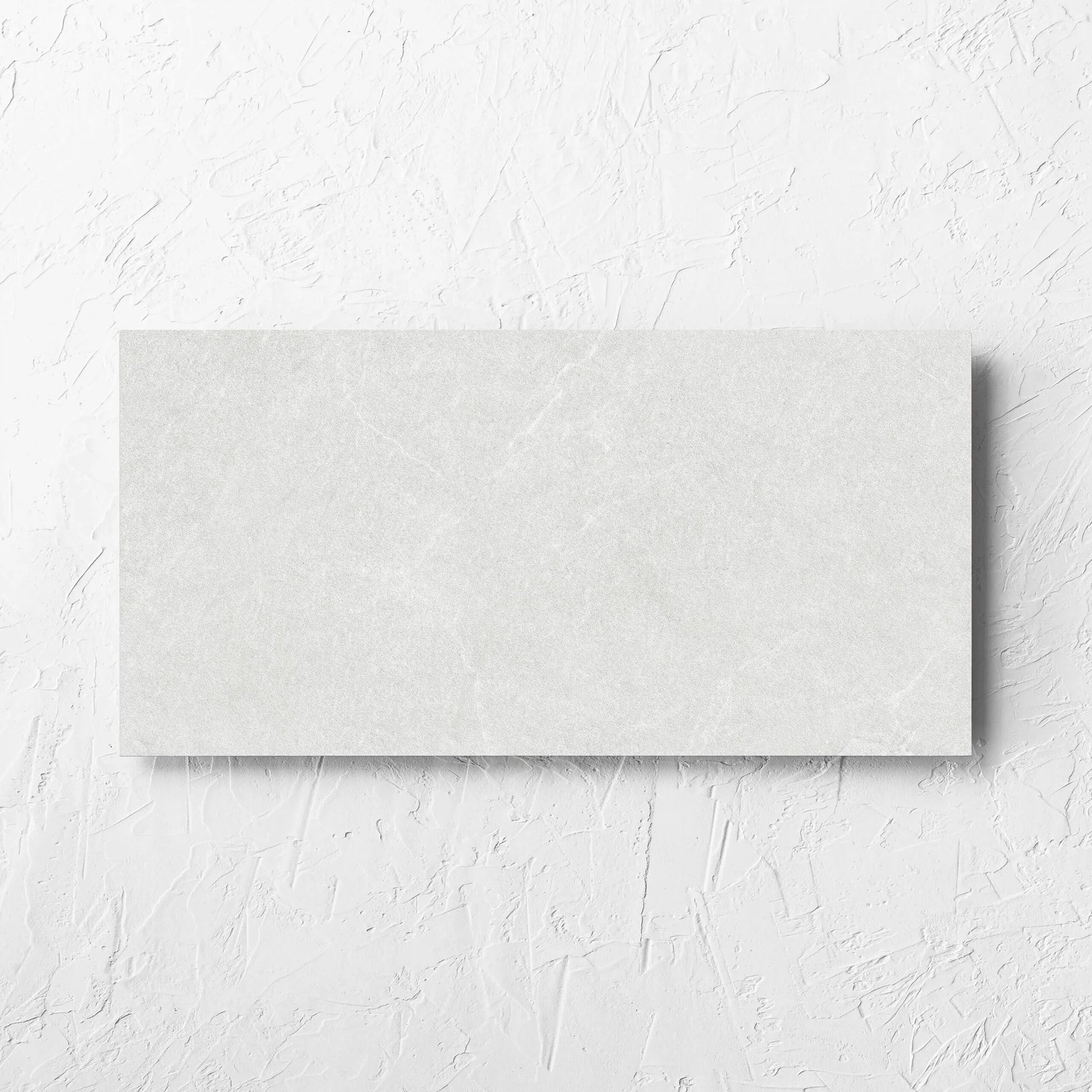 Lava White Amber 300x600mm tile laid flat on a white rendered wall, showing the tile surface