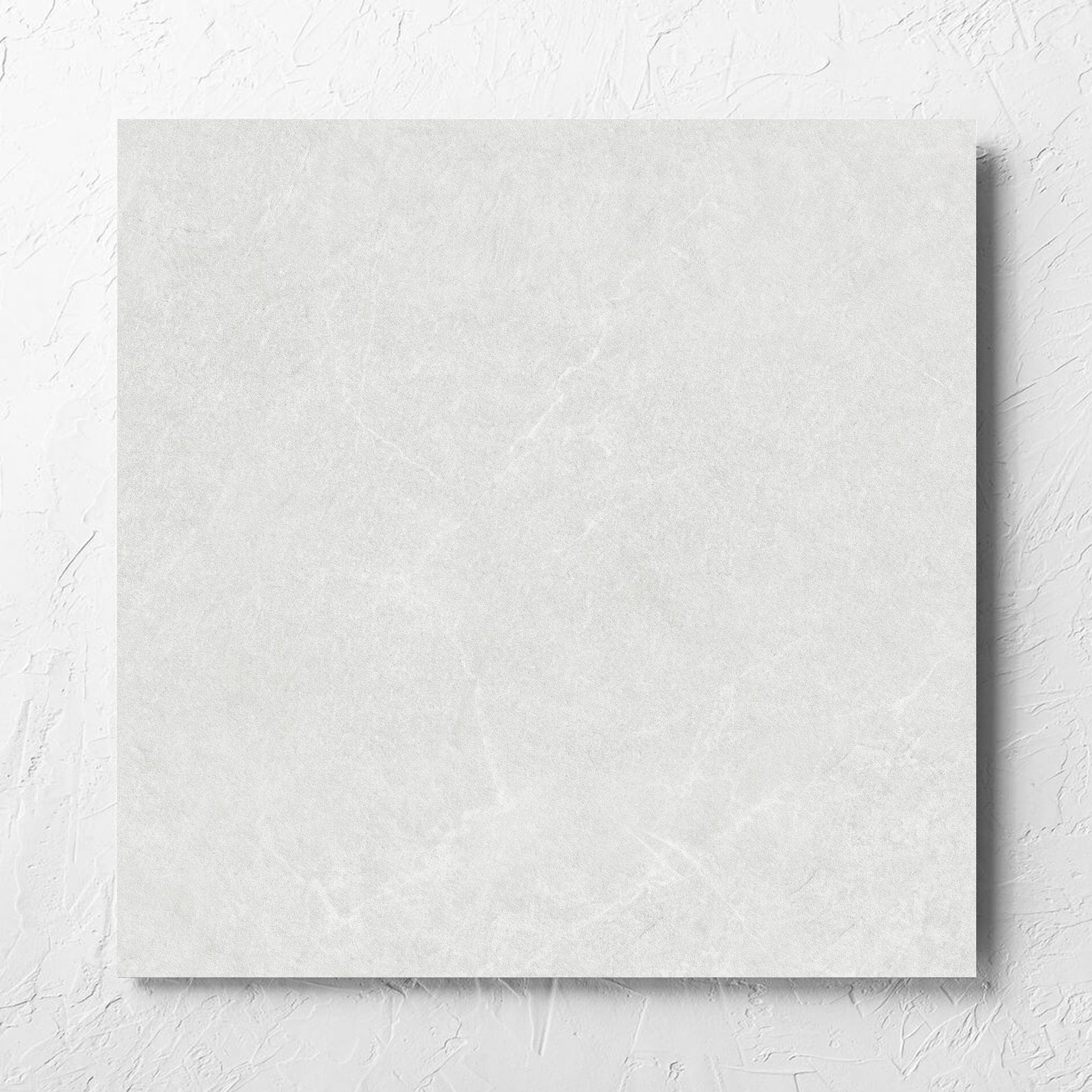 Lava White Inout 600x600mm tile laid flat on a white rendered wall, showing the white lappato surface