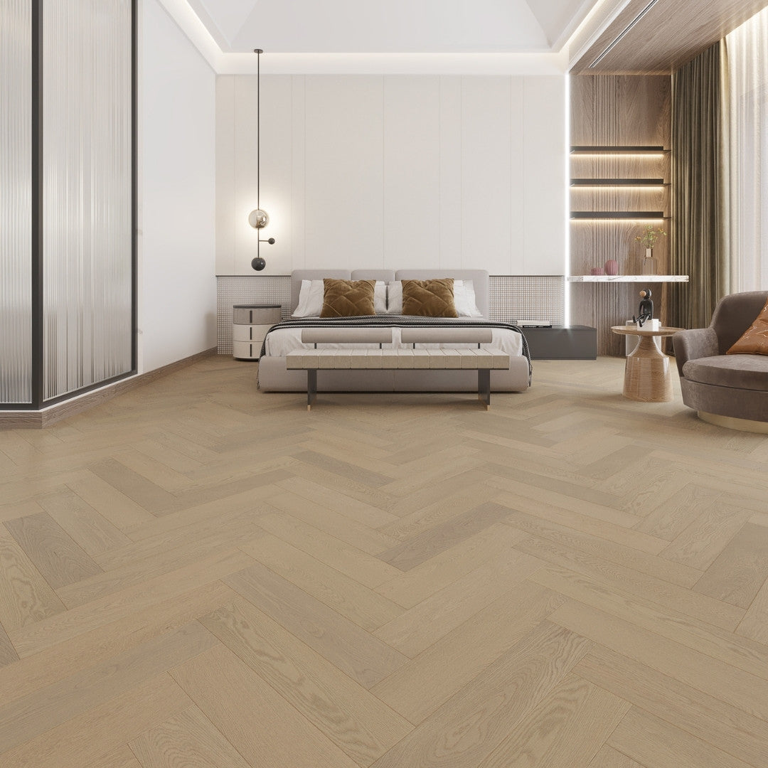 Light Neutral iDesign Herringbone Flooring 15/3mm installed in a spacious luxury bedroom with a low-profile bed, pendant light, and warm wood accent wall.