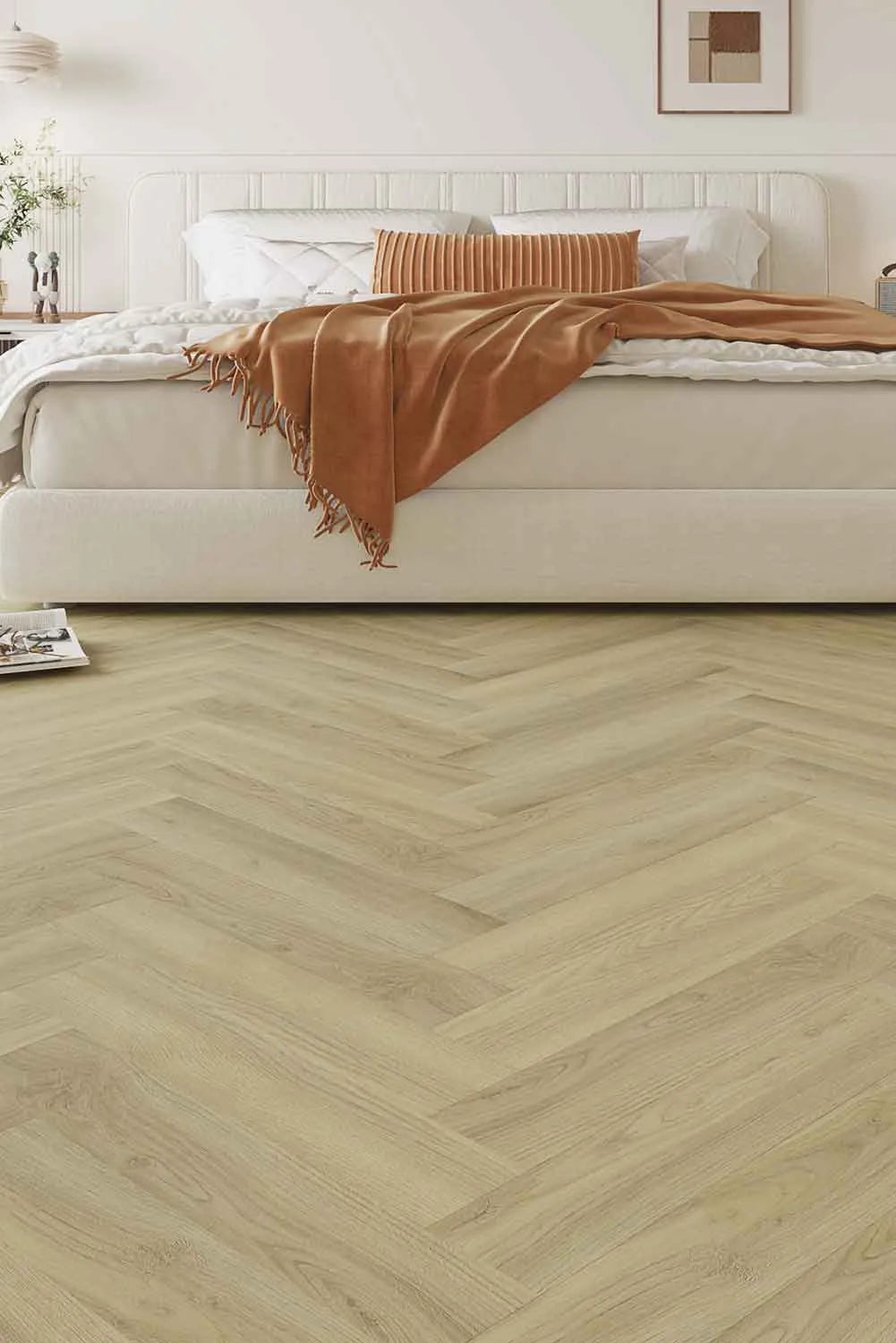 Lime Ash Elegant SPC Hybrid Herringbone 9.5mm Flooring 7.5+2mm installed in a bright bedroom with a cream upholstered bed and warm terracotta throw blanket.