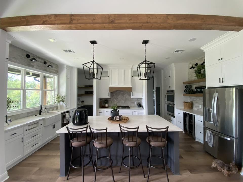 London Fog Brick Tile 60x250mm installed as a herringbone kitchen splashback behind a white gas cooktop, complemented by white shaker cabinets and black pendant lights.