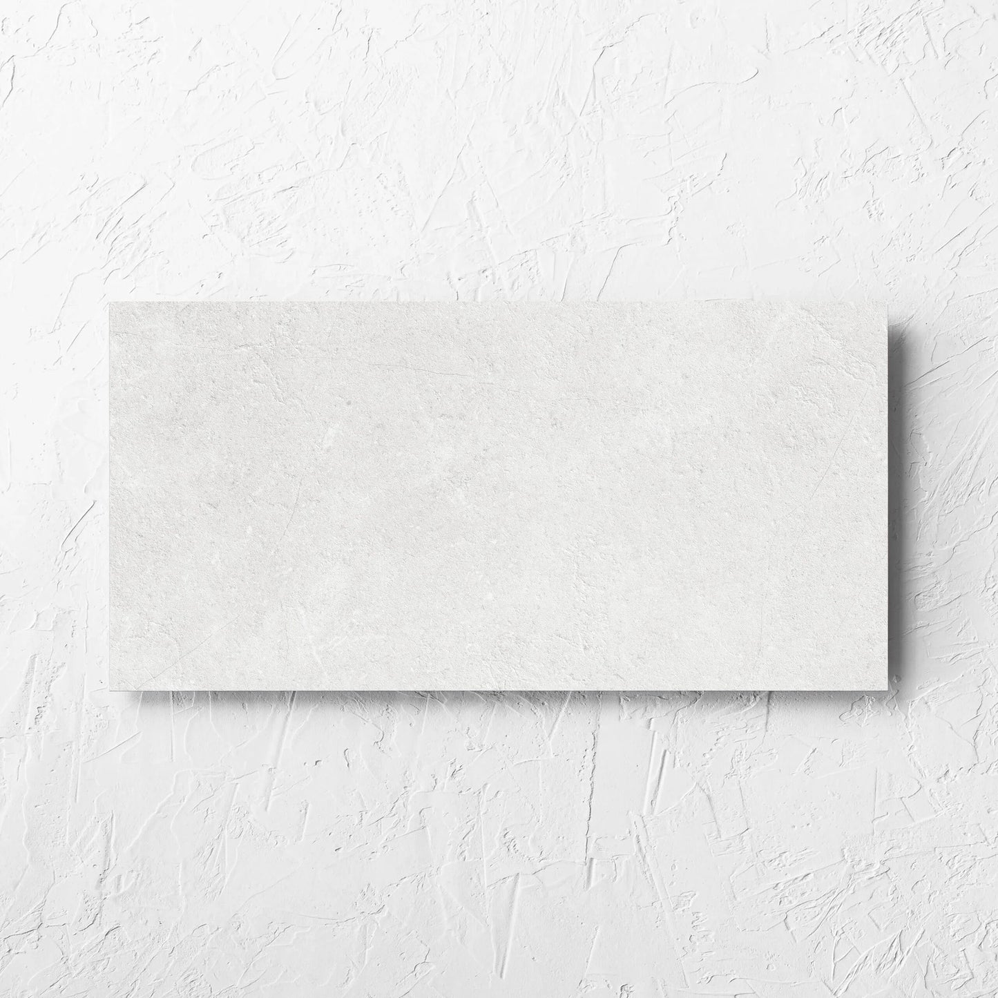 Lusso Bianco Amber 300x600mm tile laid flat on a white rendered wall, showing the matt surface