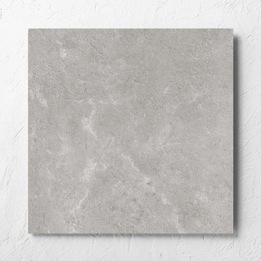 Lusso Grigio Matt 600x600mm tile laid flat on a white rendered wall, showing the matt surface