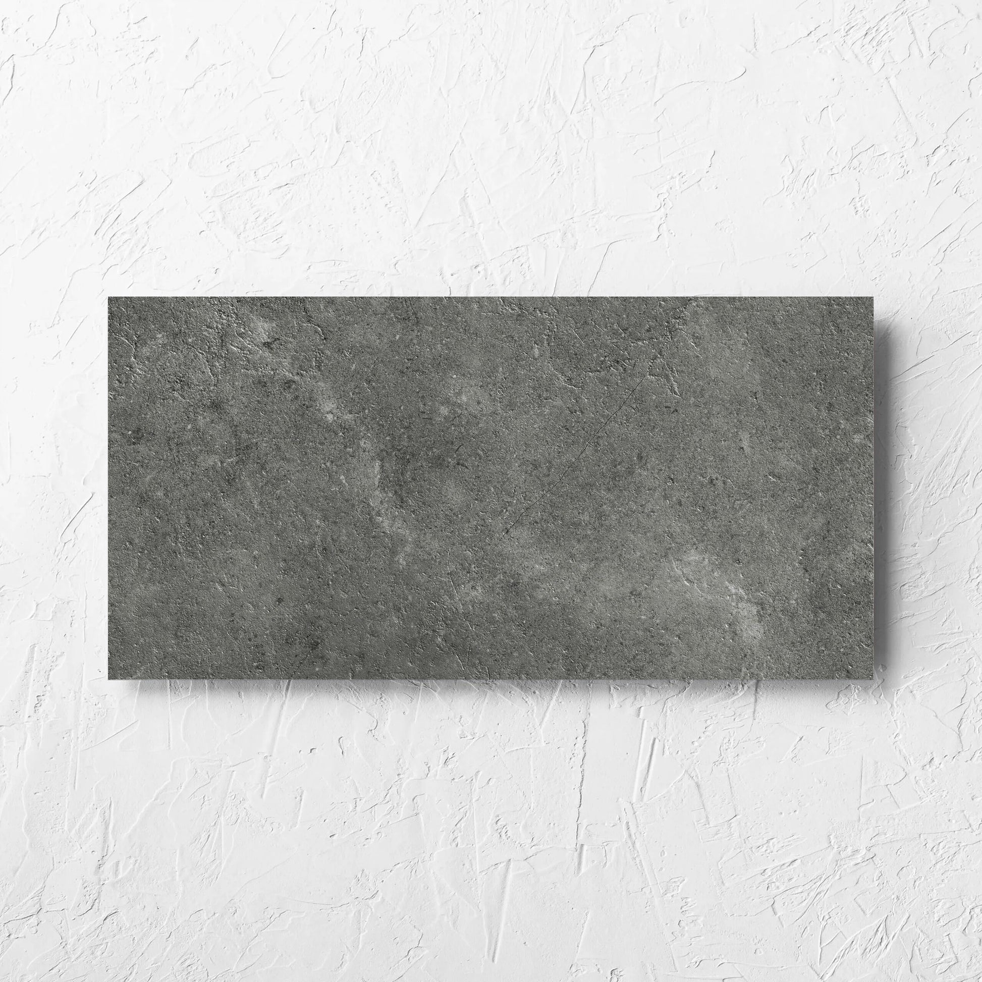 Lusso Midnight Amber 300x600mm tile laid flat on a white rendered wall, showing the matt surface