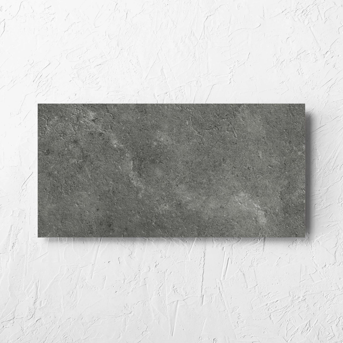 Lusso Midnight Matt 300x600mm tile laid flat on a white rendered wall, showing the matt surface