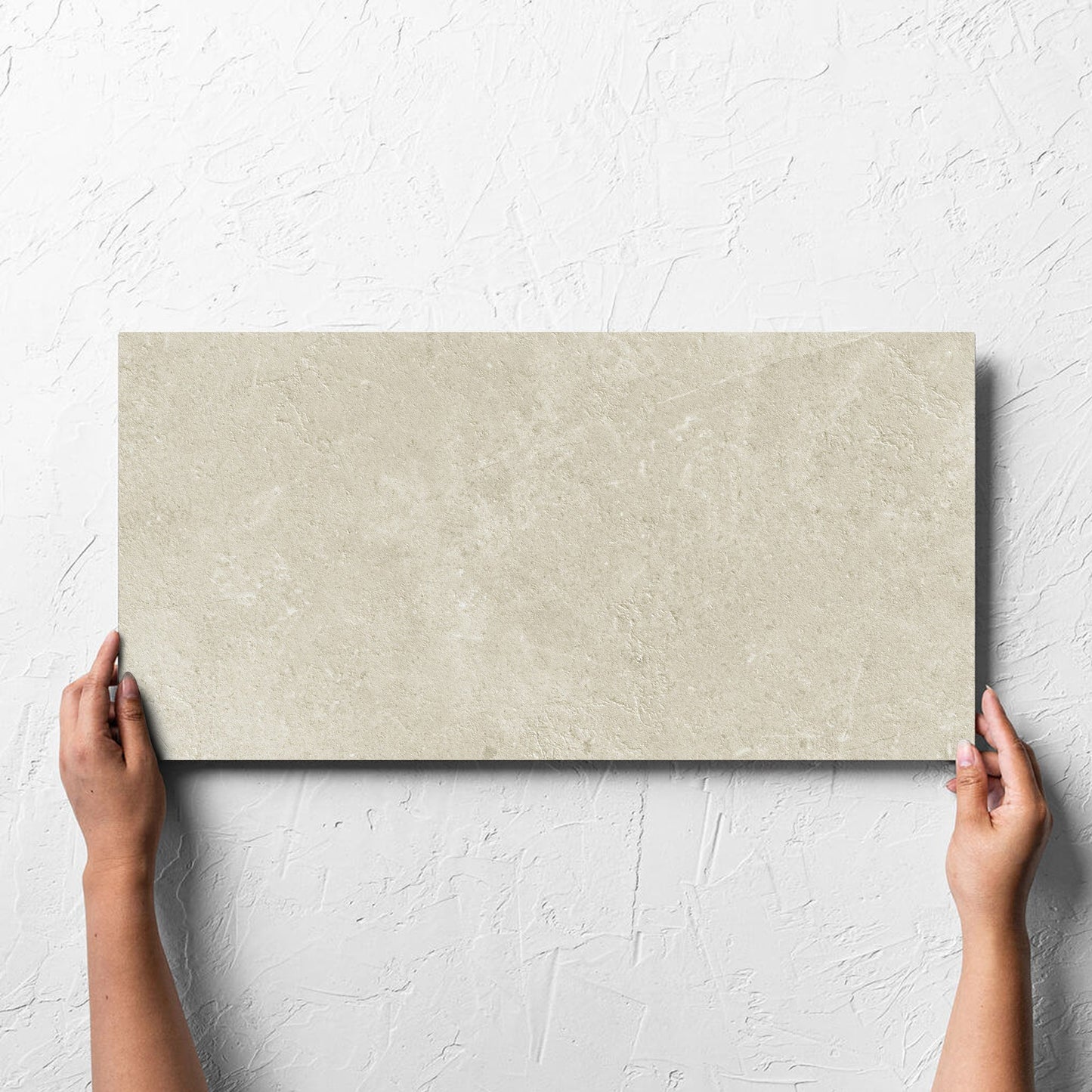 Hand holding a single Lusso Naturale Matt 300x600mm tile against a white rendered wall, showing the matt surface