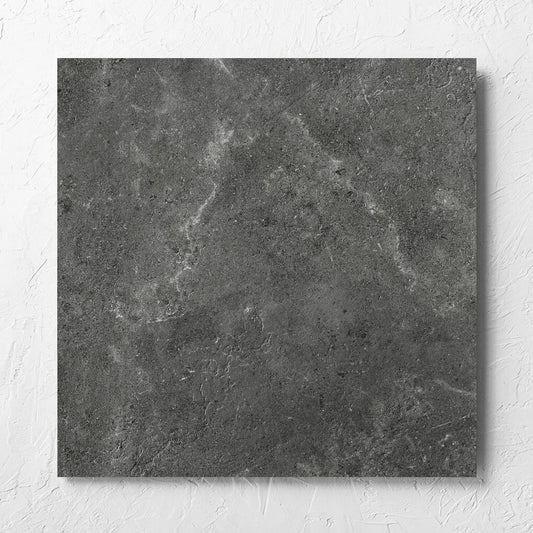 Lusso Nero Matt 600x600mm tile laid flat on a white rendered wall, showing the matt surface