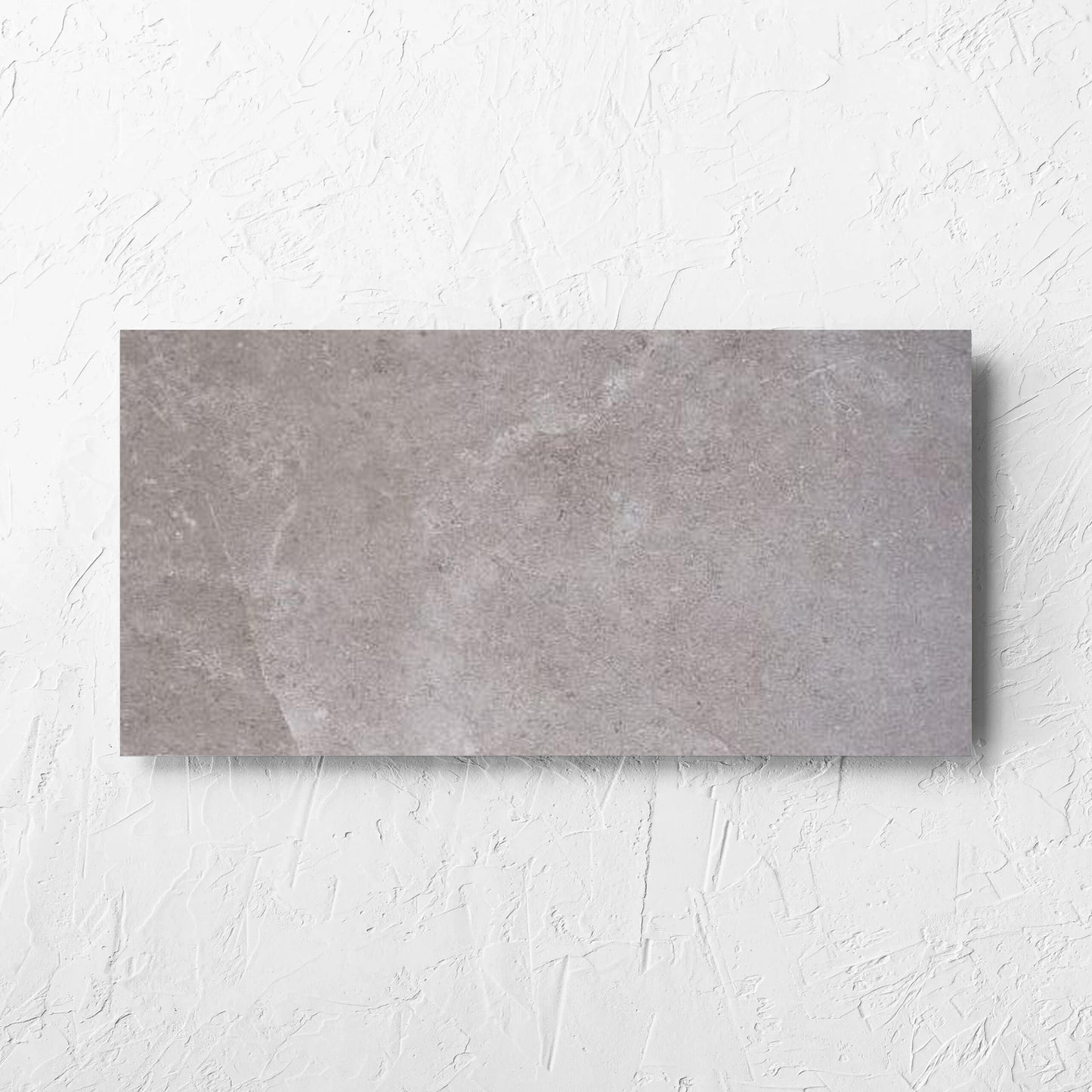 Lusso Terra Amber 300x600mm tile laid flat on a white rendered wall, showing the matt surface
