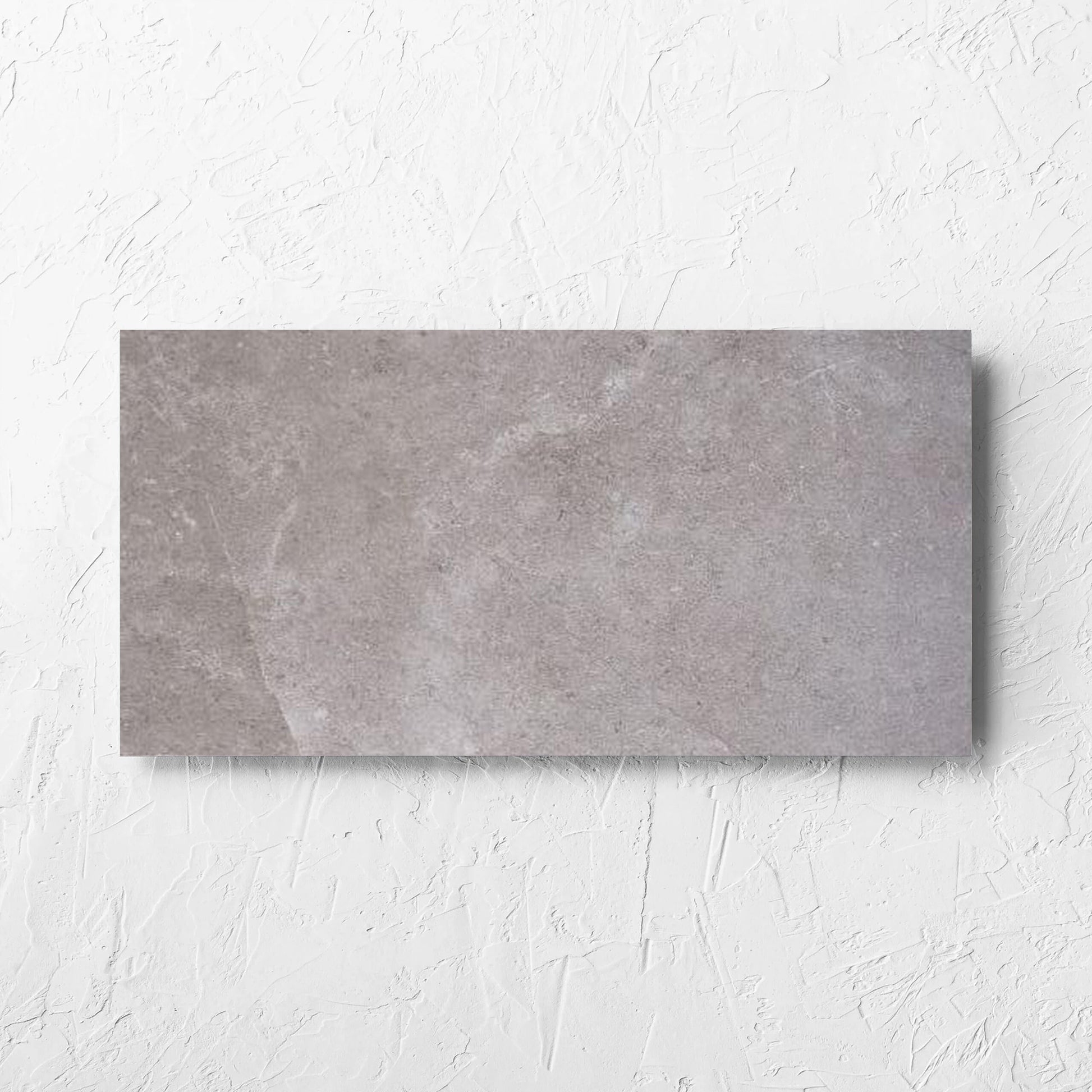Lusso Terra Amber 300x600mm tile laid flat on a white rendered wall, showing the matt surface