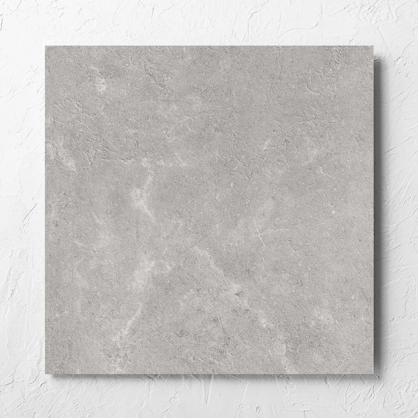 Lusso Terra Matt 600x600mm tile laid flat on a white rendered wall, showing the matt surface