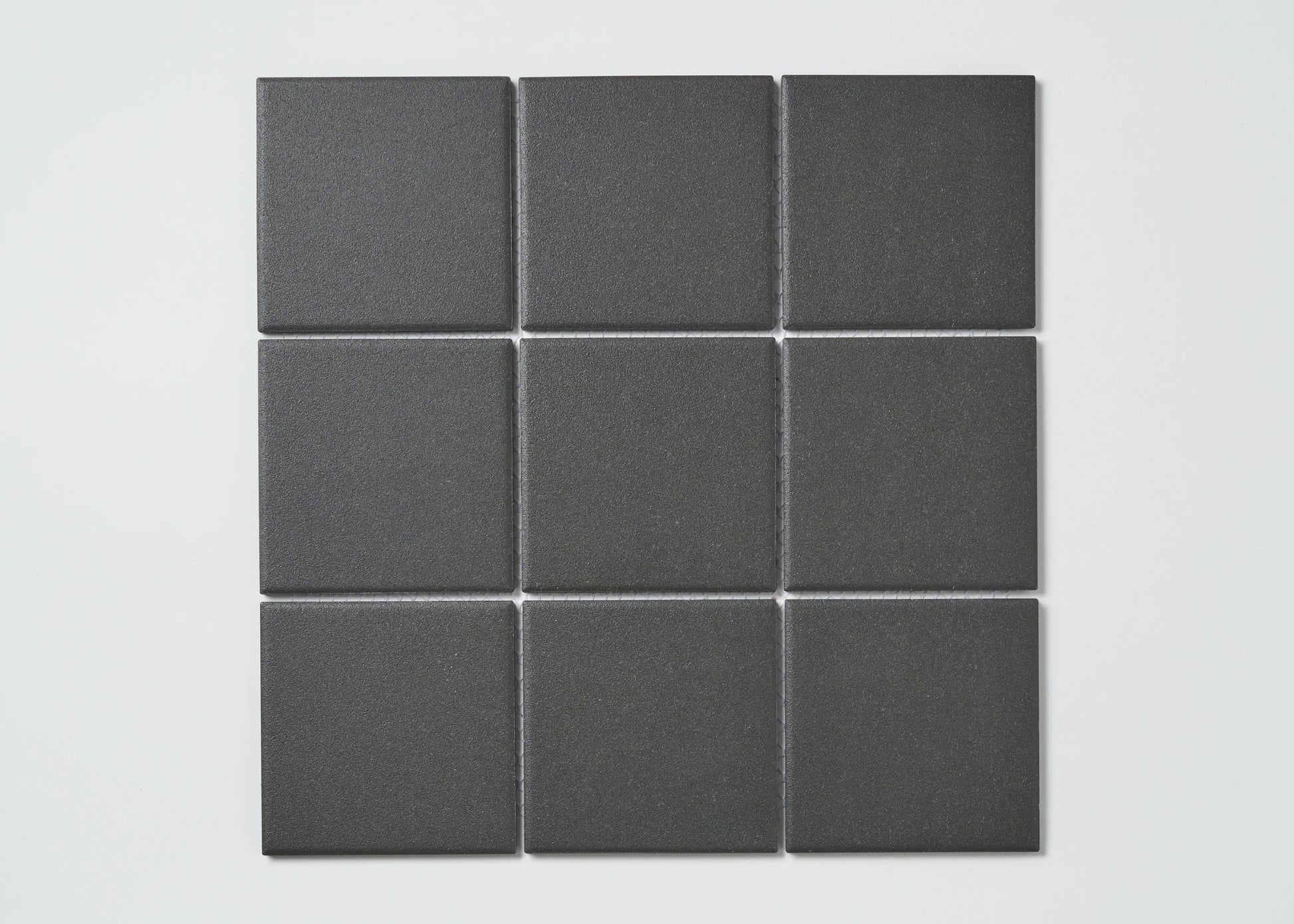 Nine Marlowe Black Matt Mosaic 97x97mm tiles arranged in a 3x3 grid, showcasing their matte charcoal finish and square format.