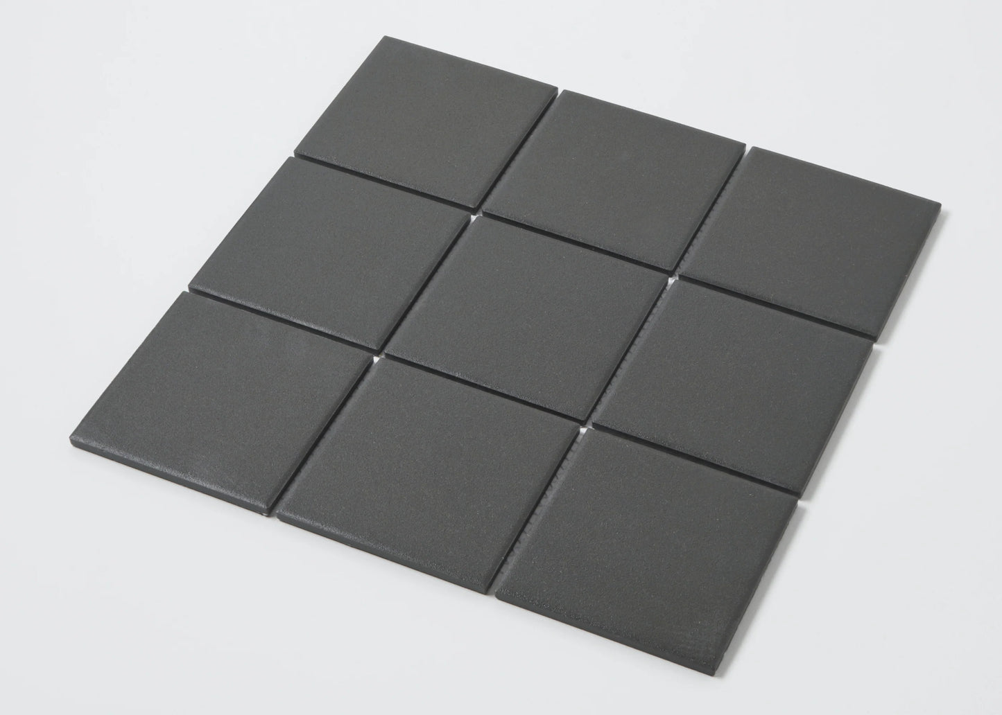Pack shot of Marlowe Black Matt Mosaic 97x97mm tiles arranged in a 3x3 grid, showing a smooth matte charcoal grey square format finish.