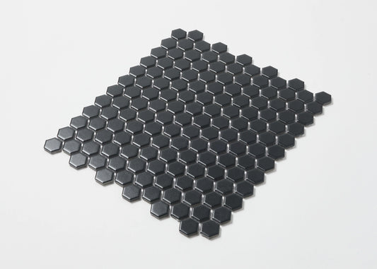 Pack shot of Marlowe Black Matt Mosaic Hexagon 23x23mm tiles arranged in a flat-lay sheet showing matte black hexagonal ceramic pieces with dark grout joints.