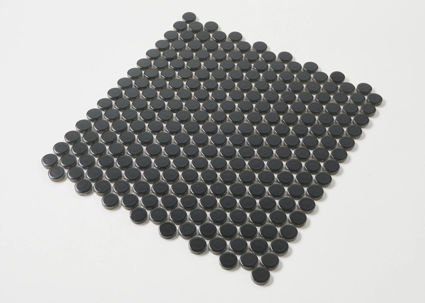 Marlowe Black Matt Penny Round 19mm mosaic tile sheet arranged in a diamond layout, showcasing the circular matte black glazed ceramic discs against a white background.