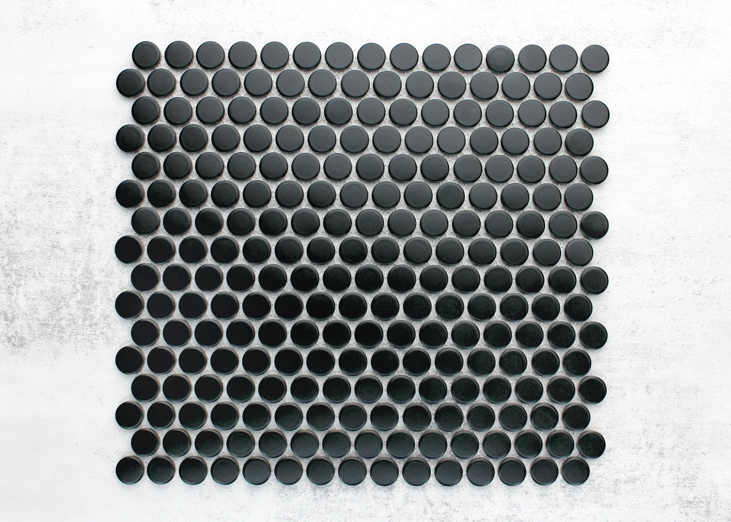 Overhead pack shot of Marlowe Black Matt Penny Round 19mm mosaic tile sheet showing uniform matte black circular tiles arranged in an offset grid pattern.