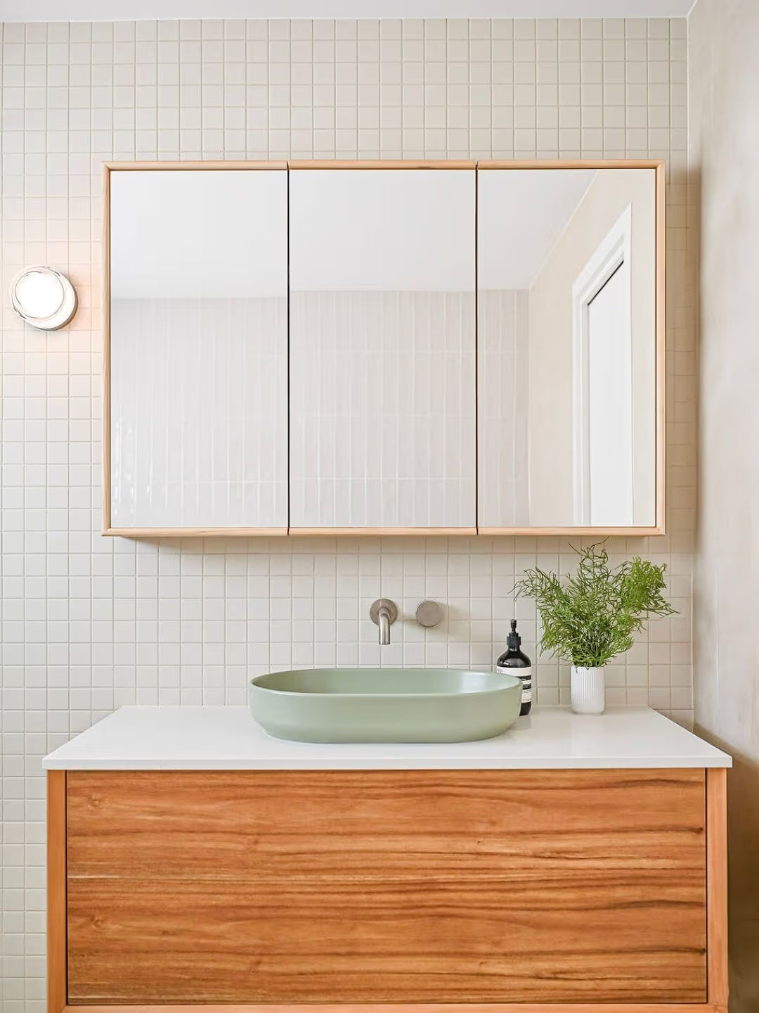 Marlowe Bone Matt Mosaic 48x48mm tiles covering a bathroom wall behind a timber floating vanity with a sage green vessel sink.