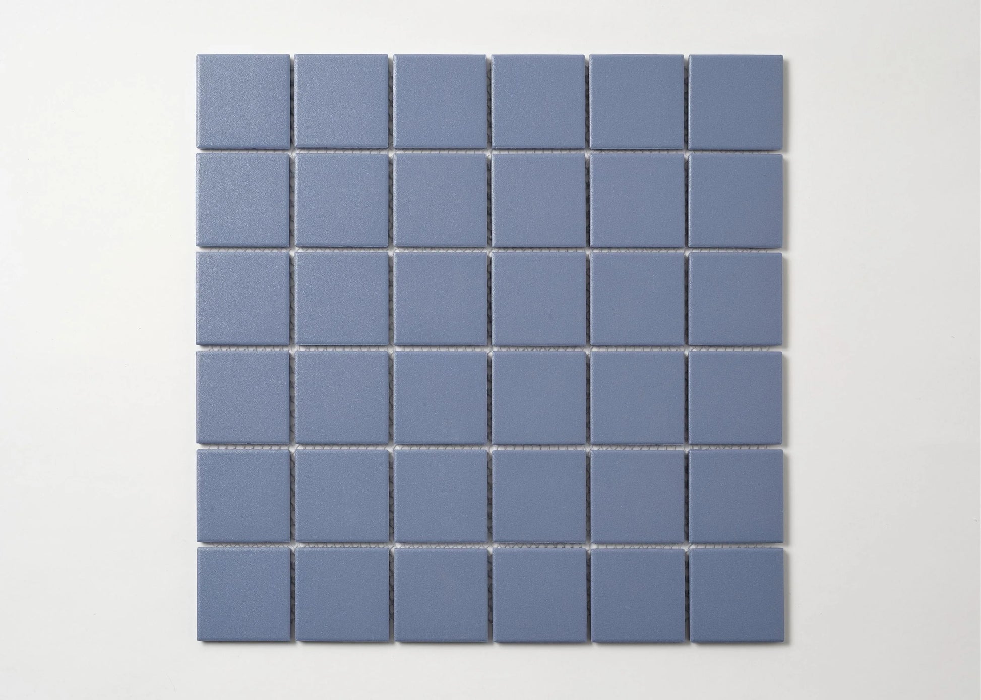 Pack shot of Marlowe Cornflower Blue Matt Mosaic 48×48 mm showing a flat grid of square matte blue-grey ceramic tiles with uniform grout joints.