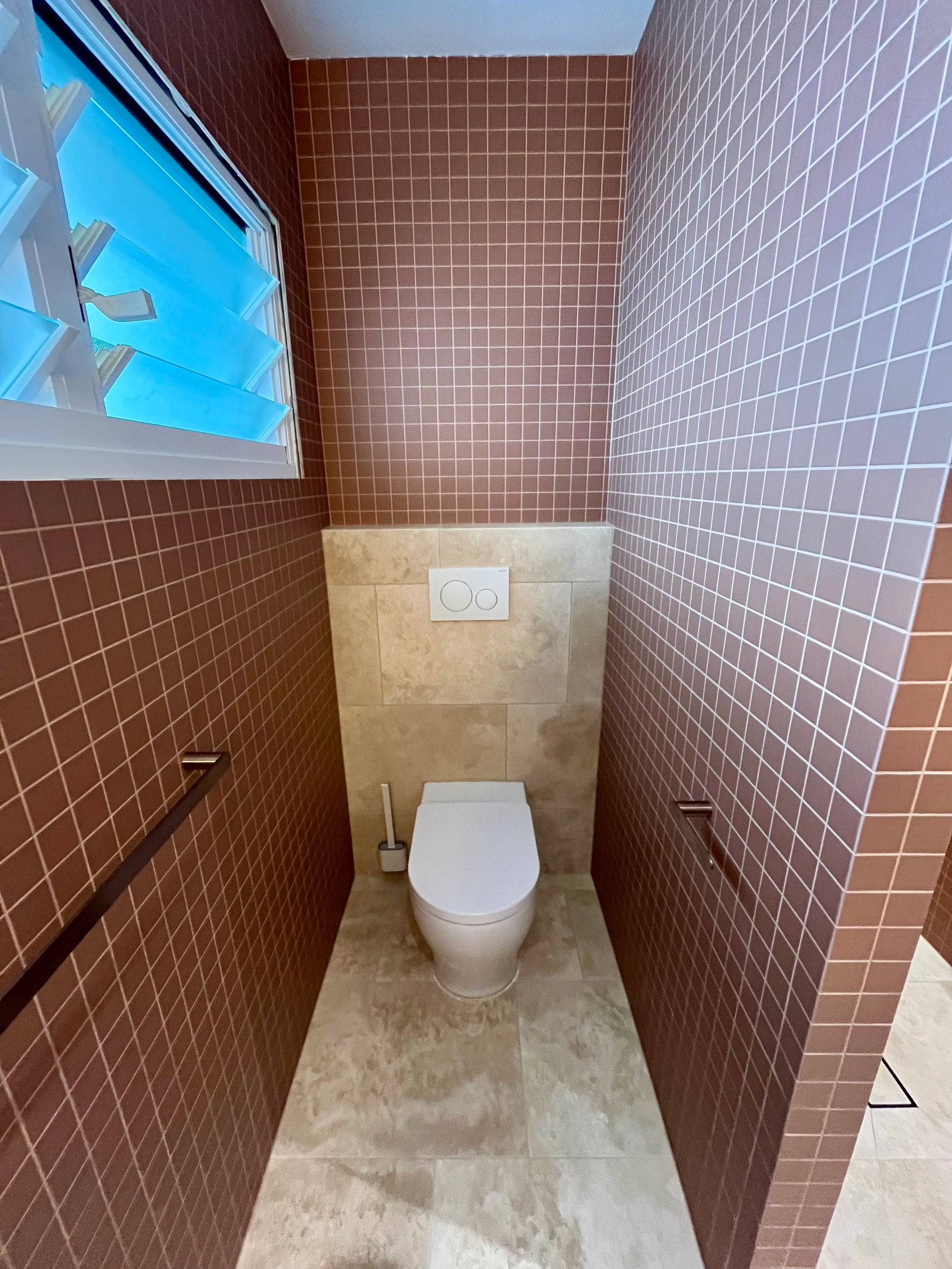 Marlowe Terracotta Matt Mosaic 48x48mm tiles covering floor-to-ceiling walls in a narrow toilet room with wall-hung pan and louvred window.