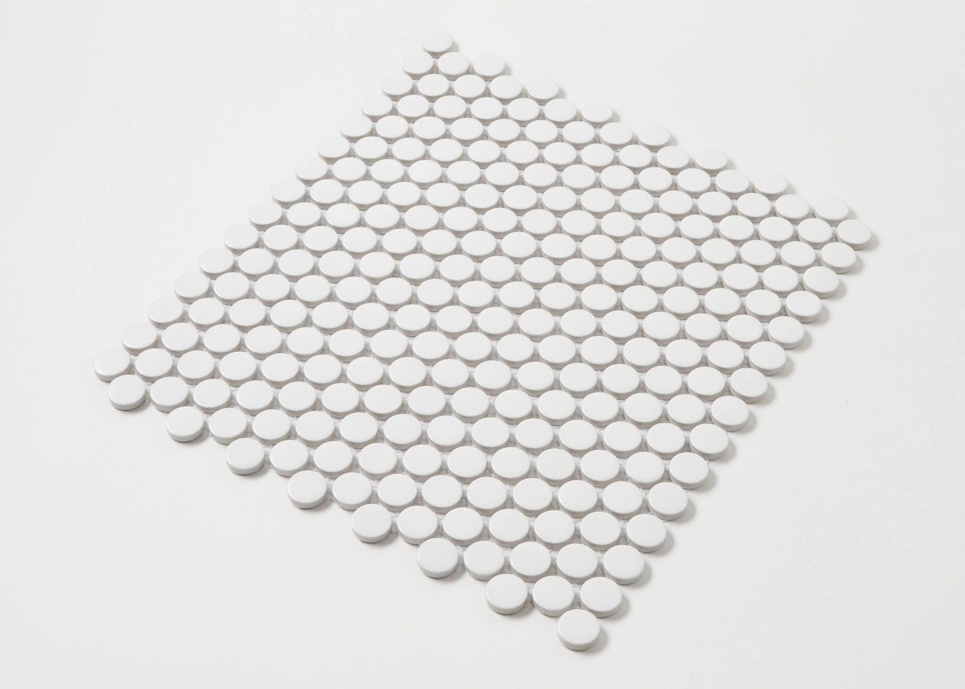 Marlowe White Matt Penny Round 19mm mosaic tile sheet displayed in a diamond orientation, showing small circular white matte ceramic tiles on a mesh backing.