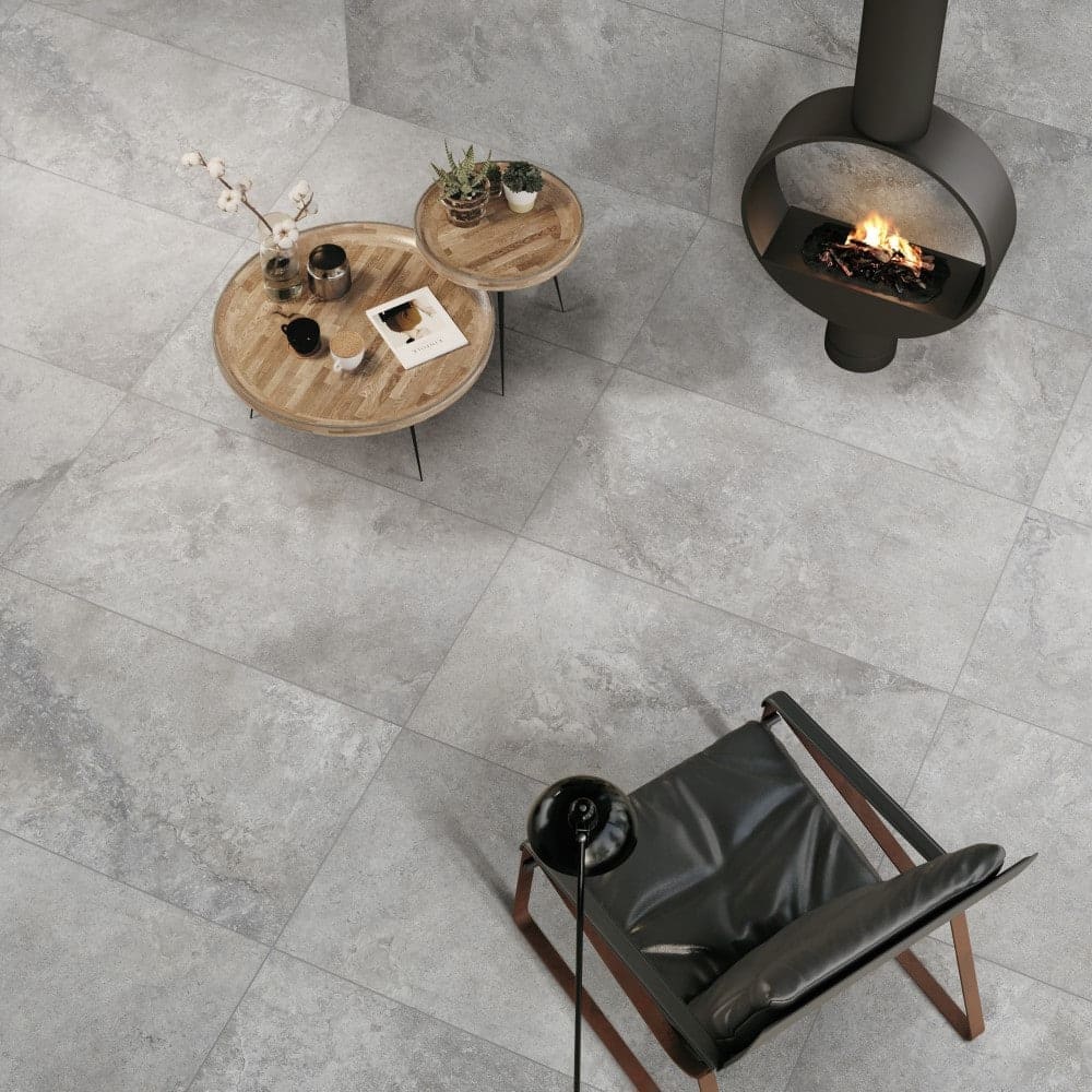 Mars Cinder External Pencil Bullnose 390.8x600x20mm grey stone-look floor tiles styled in a modern living room with a suspended fireplace and wooden coffee tables.