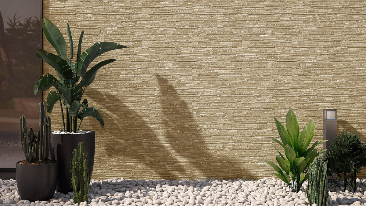 Maule Beige Matt 170x520mm stacked stone-effect wall tiles installed on an exterior facade surrounded by tropical plants and white pebble landscaping.