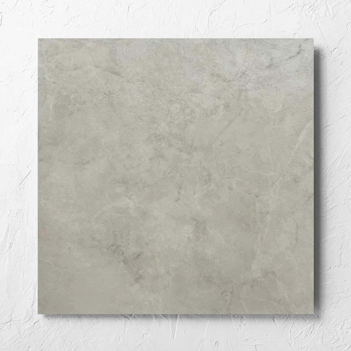 Memory Stone Beige Matt 600x600mm tile laid flat on a white rendered wall, showing the tile surface