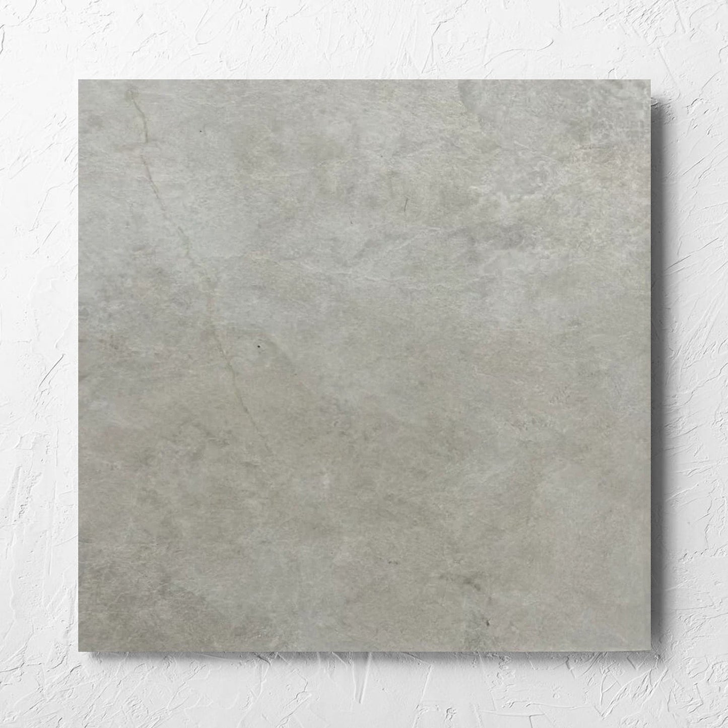 Memory Stone Bianco Matt 600x600mm tile laid flat on a white rendered wall, showing the tile surface