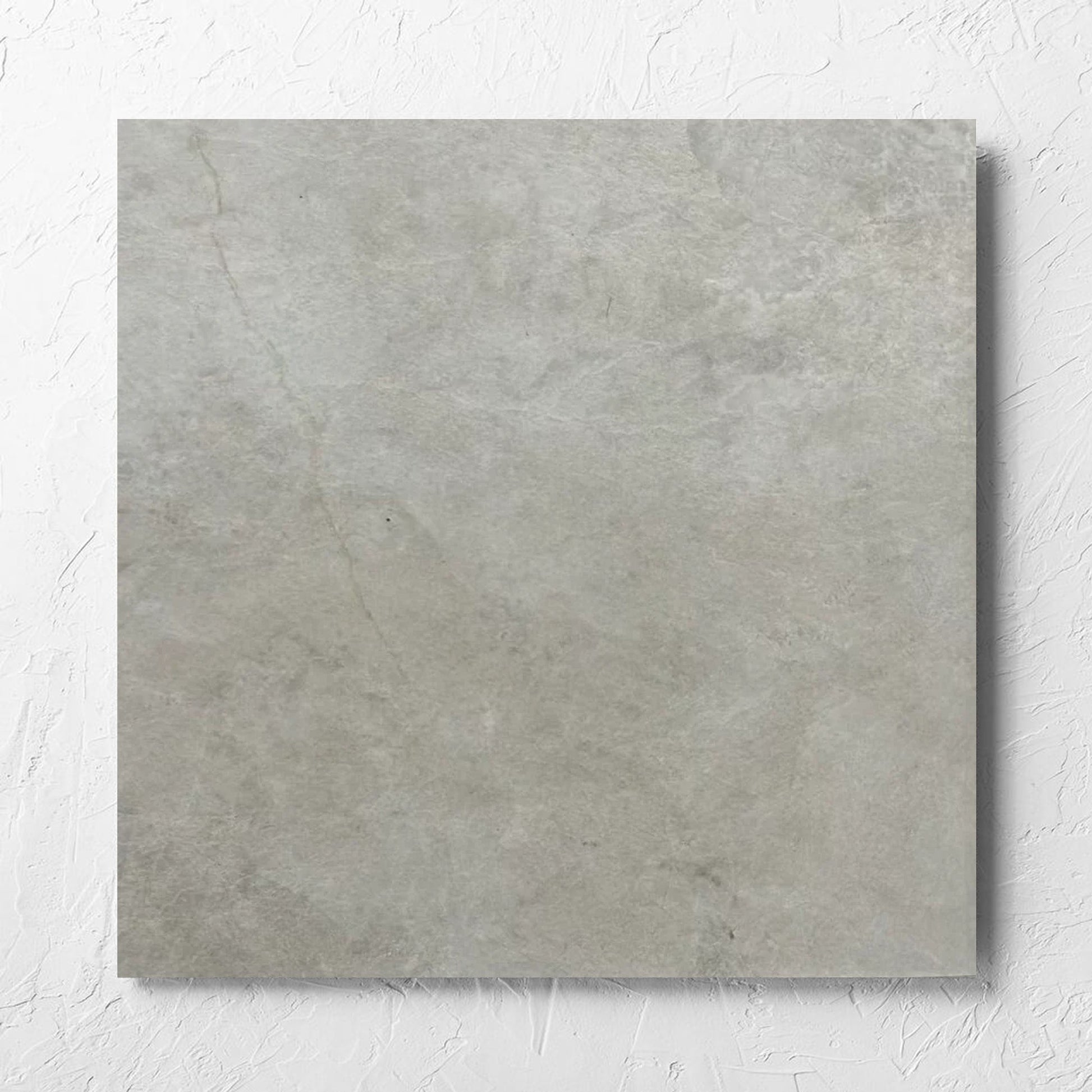 Memory Stone Bianco Matt 600x600mm tile laid flat on a white rendered wall, showing the tile surface