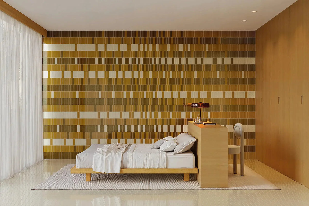 Micare Ambar Dark Gloss 50x150mm tiles cover a full bedroom feature wall in golden amber tones, complemented by a timber bed frame and copper bedside lamp.