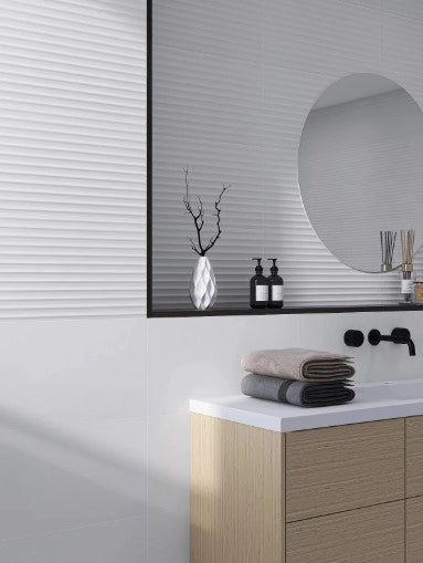 Micro Flute Matt White 300x600mm tiles installed as a full bathroom wall behind a timber vanity with round mirror and matte black tapware.