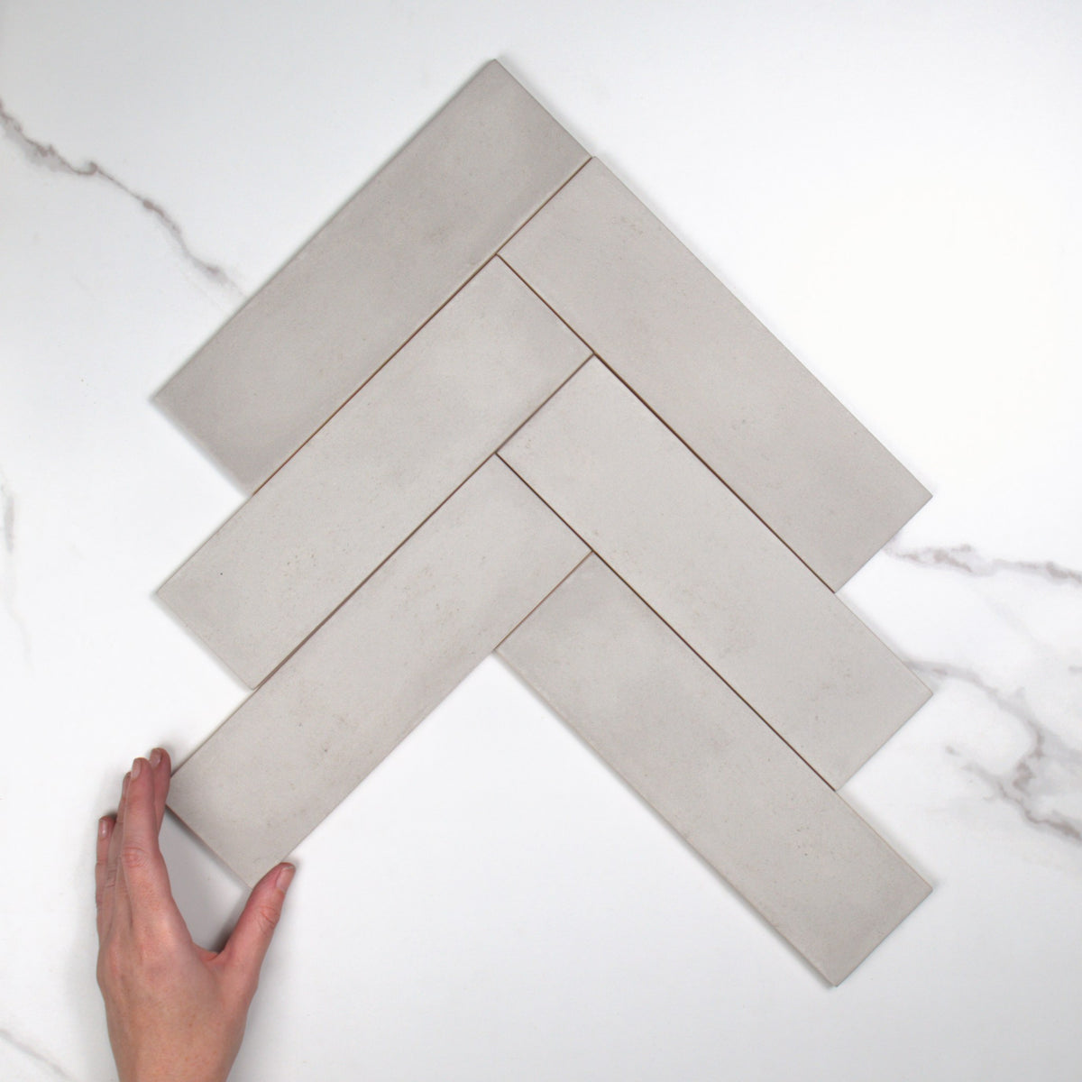 Milano Grigio Matt 69x240mm top view, hand for scale