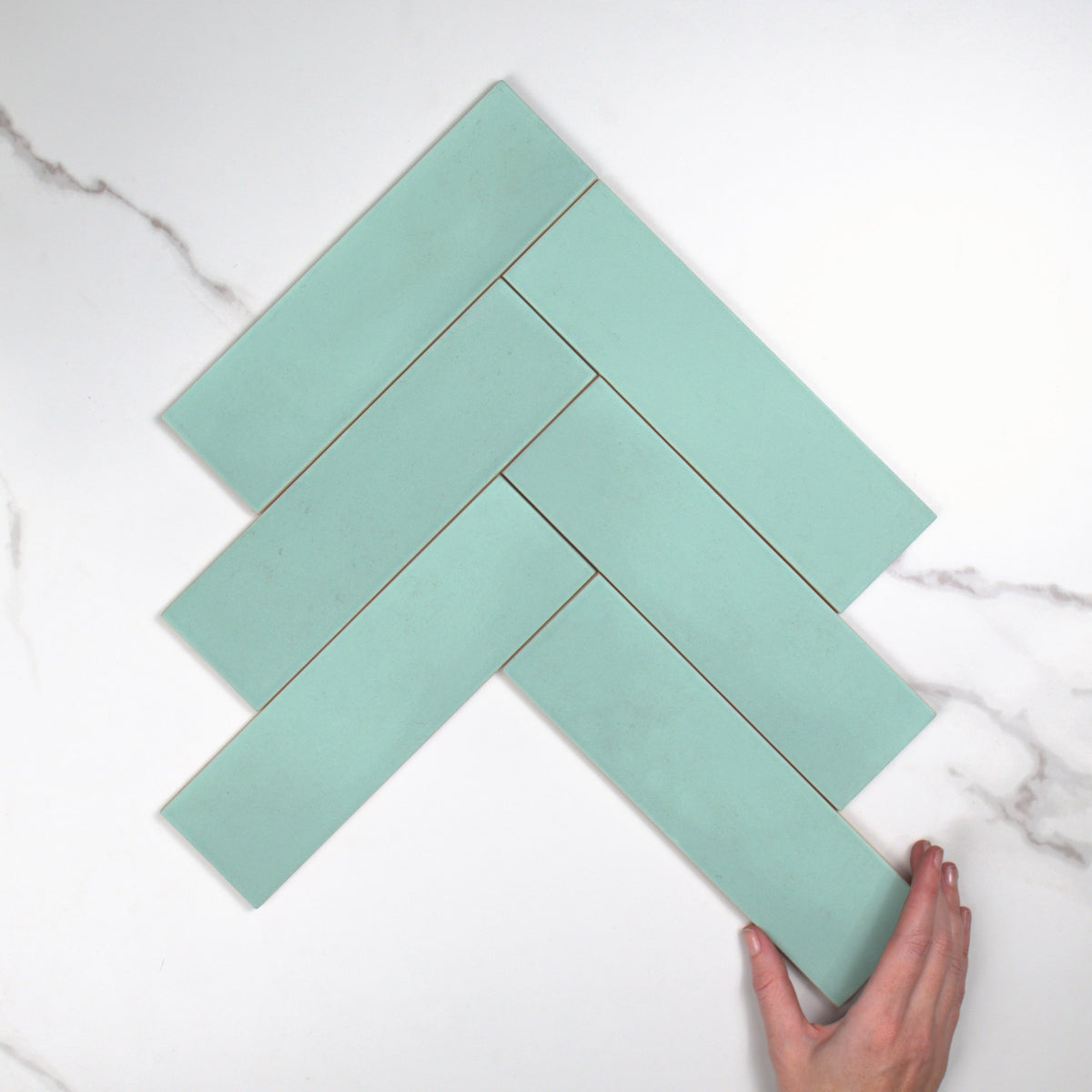 Milano Menta Matt 69x240mm top view, hand for scale