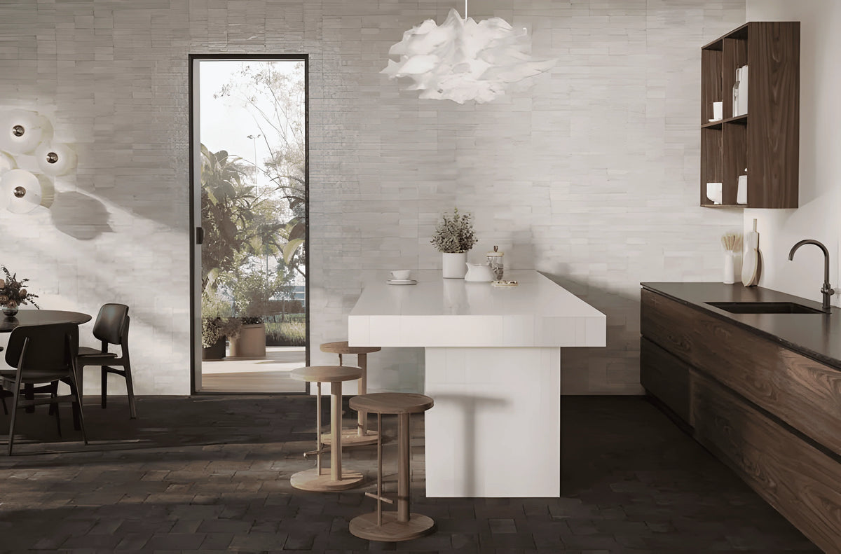 Mini Pure White Glossy 50x150mm tiles covering a textured kitchen wall behind a white island bench, wooden cabinetry, and sculptural cloud pendant light.