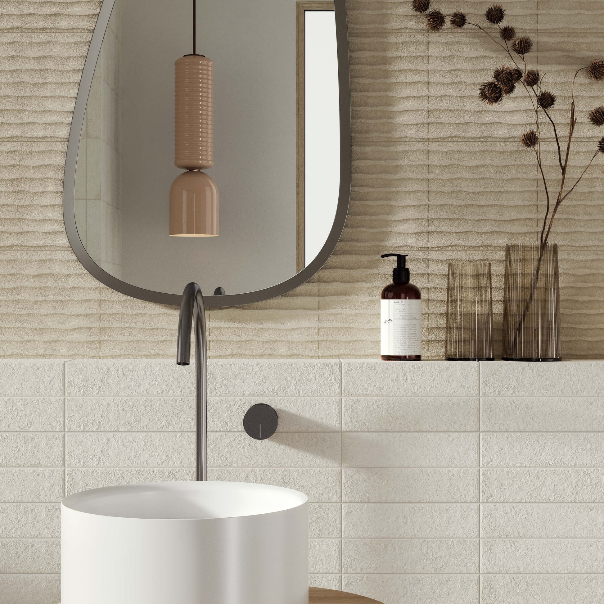 Miniature Fornace Bianco Minerale 60x240mm tiles installed in a modern bathroom featuring a round pedestal basin, arched mirror, and ceramic pendant light.