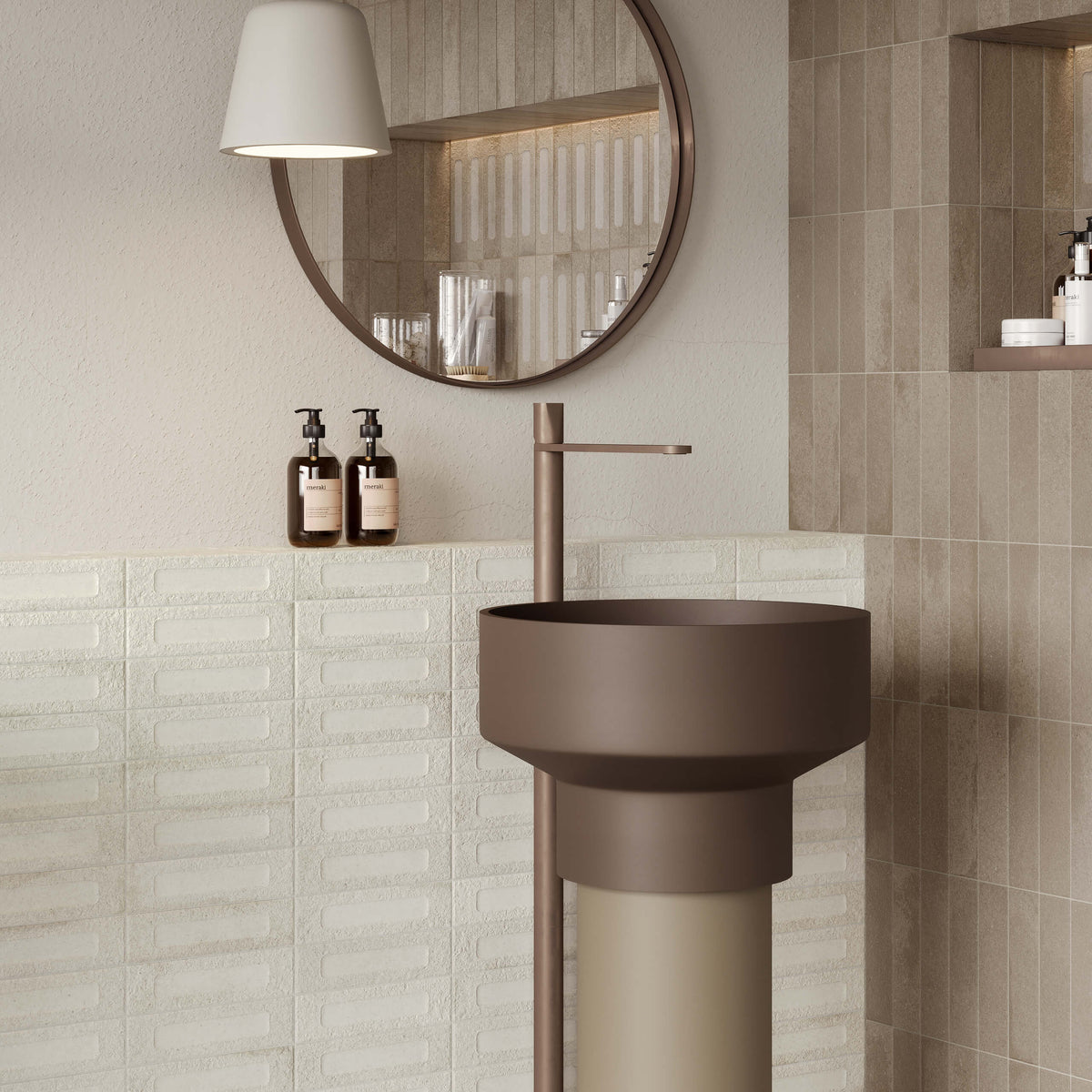 Miniature Fornace Formella Bianco Minerale 60x240mm wall tiles installed in a modern bathroom featuring a cylindrical pedestal sink, round mirror, and warm pendant light.