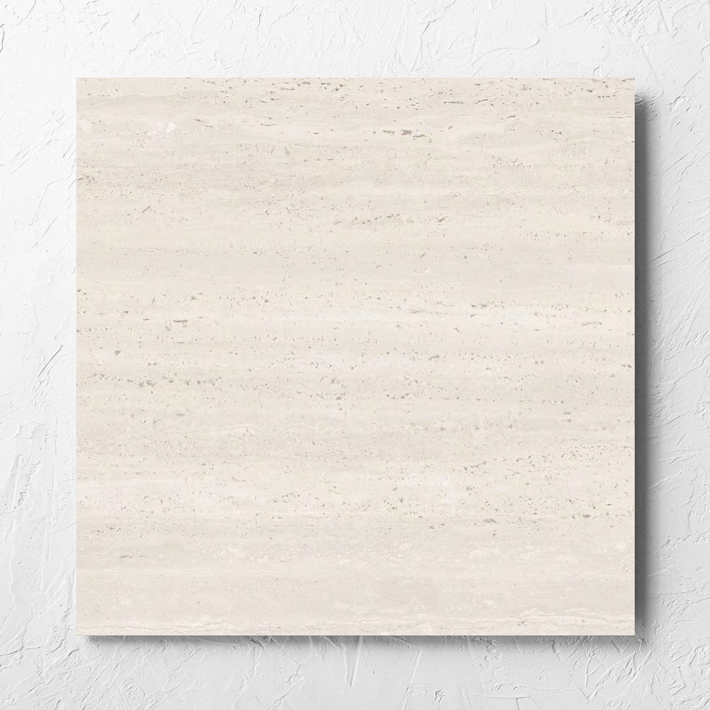 Tallow Vein Cut Travertine Look Ivory 600x600mm tile laid flat on a white rendered wall, showing the beige matt surface