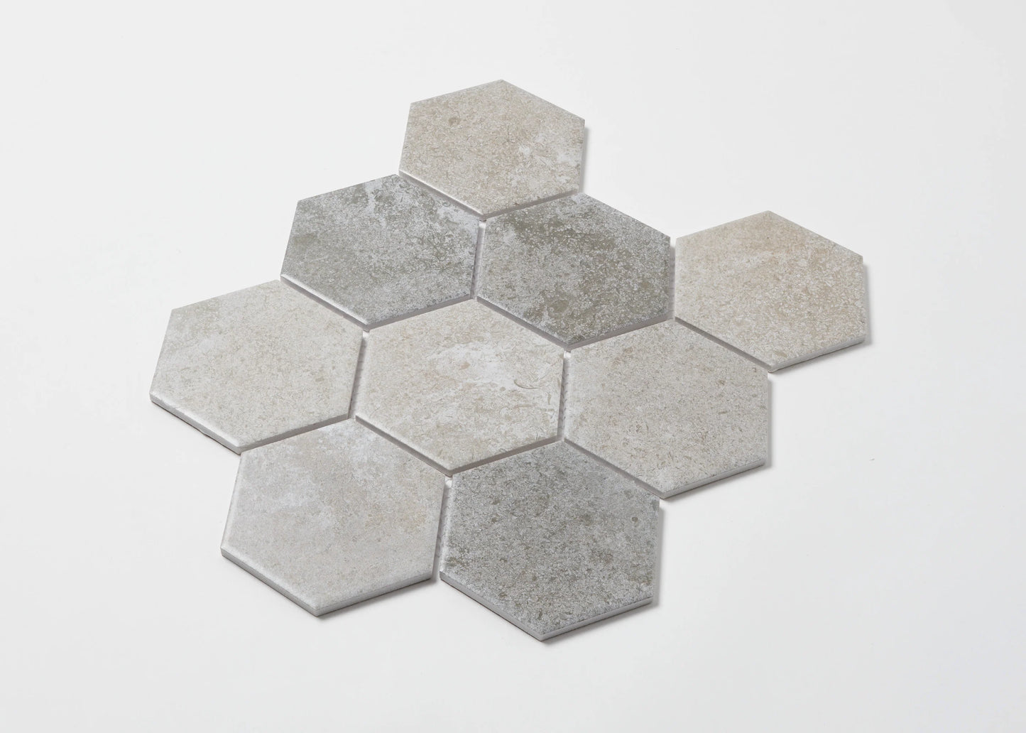 Pack shot of Mixed Colours Matte Porcelain Glazed Hexagon 95x110mm tiles arranged in a honeycomb cluster, showing varied grey and beige matte stone-look finishes.