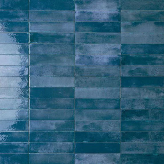 Mojave Blue Brick 60x250mm tiles shown in a stacked vertical pattern with a glossy, handcrafted finish in deep teal blue tones.