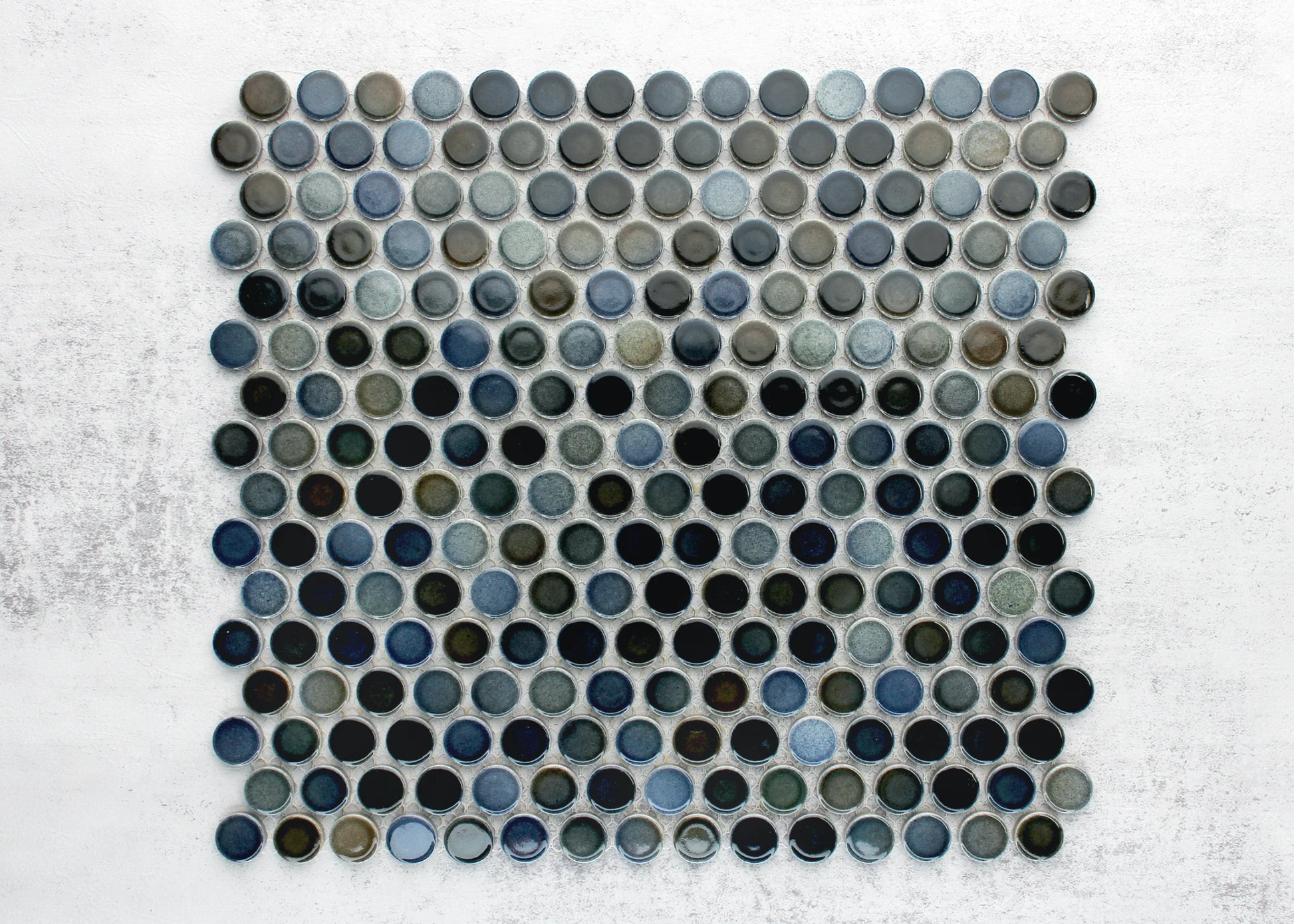 Pack shot of Mottled Mix Gloss Diameter Glazed Porcelain Penny Round 19mm tiles showing a mosaic sheet of glossy circular penny rounds in varied blue, grey, and dark teal glazes on a white background.