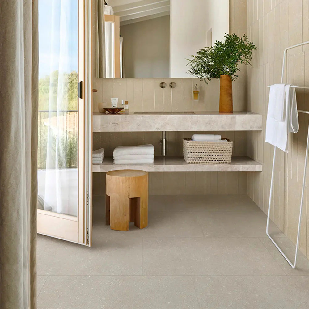 Mystone Berici Grigio Naturale 600x1200mm tiles laid on a bathroom floor beneath a floating marble vanity with open shelving and wooden stool.