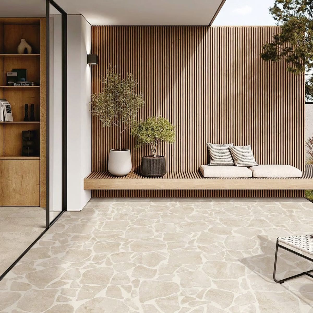 Norcia Beige Crazy Pave 10Mm 600x600mm tiles covering a modern outdoor patio floor beside a timber slat wall with built-in bench seating and potted olive trees.