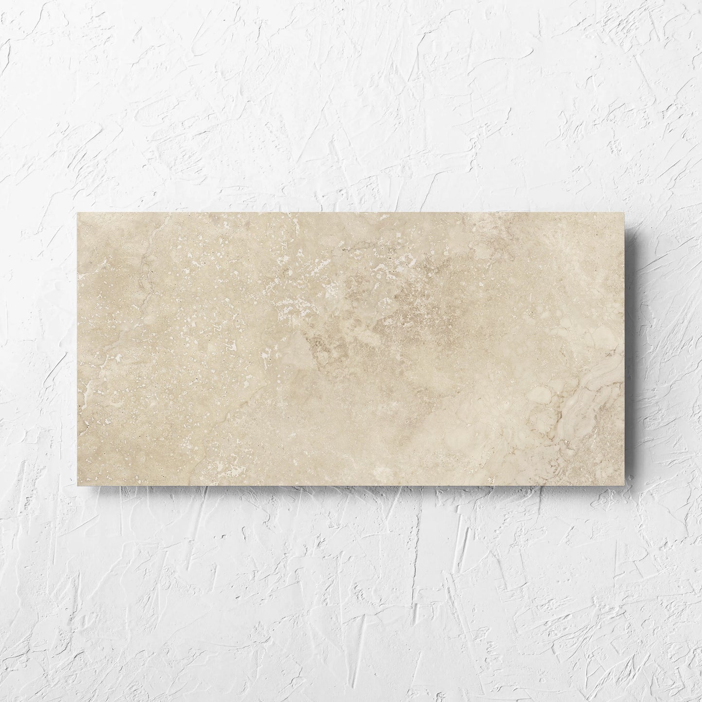 Norcia Travertine Beige 300x600mm tile laid flat on a white rendered wall, showing the beige matt surface